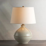 Inspired by rustic pottery, this table lamp's beautifully shaped base is crafted of pale sage ceramic giving it an earthy pale green tone. The off white linen shade pairs naturally and casts a soft glow. Raised seamlines and a reactive glaze that allows hints of the natural ceramic to peek through, give the fixture a hand-thrown, crafted feel. Amethyst Home provides interior design, new home construction design consulting, vintage area rugs, and lighting in the Kansas City metro area.