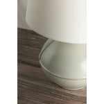 Inspired by rustic pottery, this table lamp's beautifully shaped base is crafted of pale sage ceramic giving it an earthy pale green tone. The off white linen shade pairs naturally and casts a soft glow. Raised seamlines and a reactive glaze that allows hints of the natural ceramic to peek through, give the fixture a hand-thrown, crafted feel. Amethyst Home provides interior design, new home construction design consulting, vintage area rugs, and lighting in the Laguna Beach metro area.