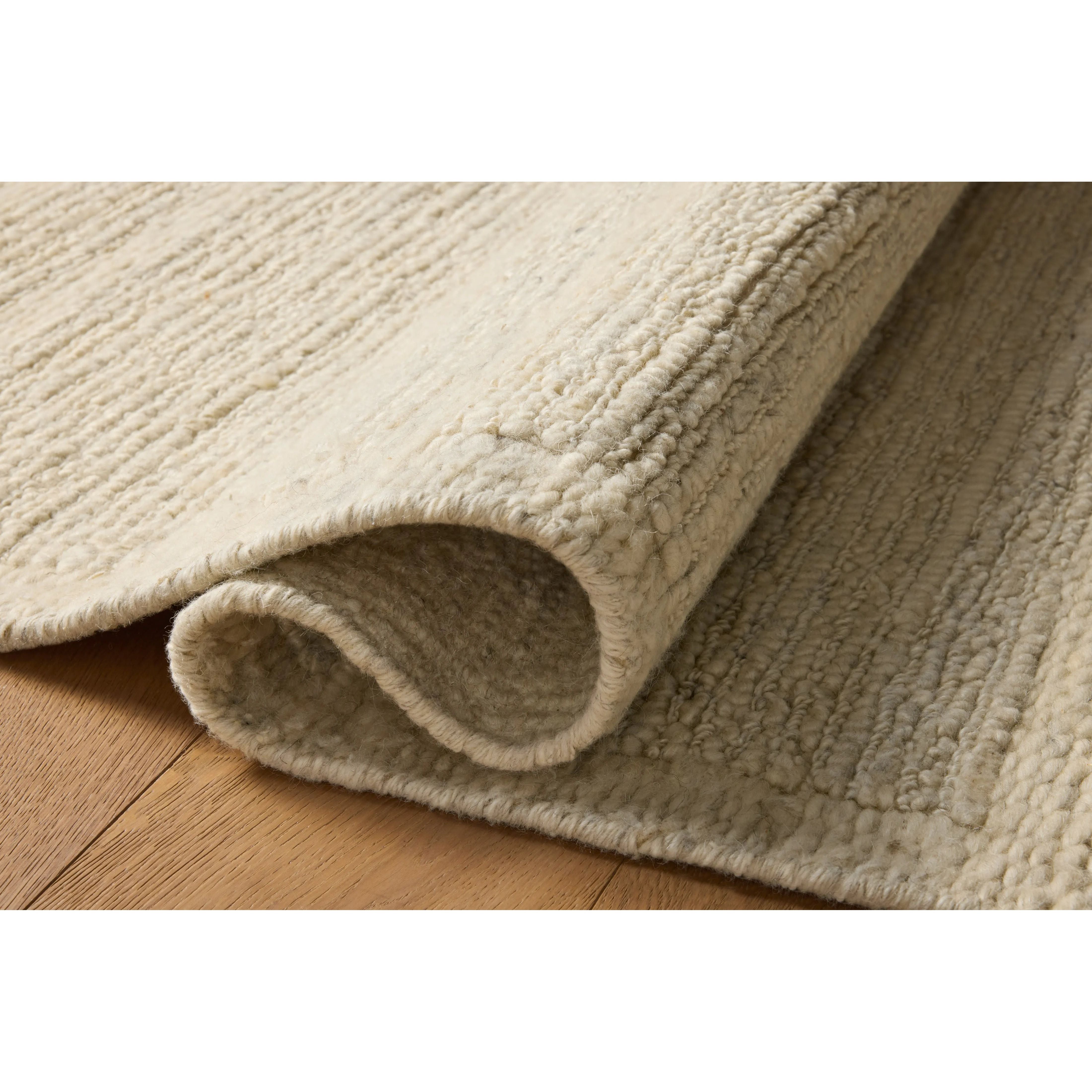 The Lennox Collection by Leanne Ford x Loloi is a statement area rug made with natural undyed wool that reveals subtle color differentiation in creamy neutral tones. The rug is hand-woven with a labor-intensive soumak weave, alternating rows of thick and thin looped yarns for an organic, inviting texture. Amethyst Home provides interior design, new home construction design consulting, vintage area rugs, and lighting in the Nashville metro area.