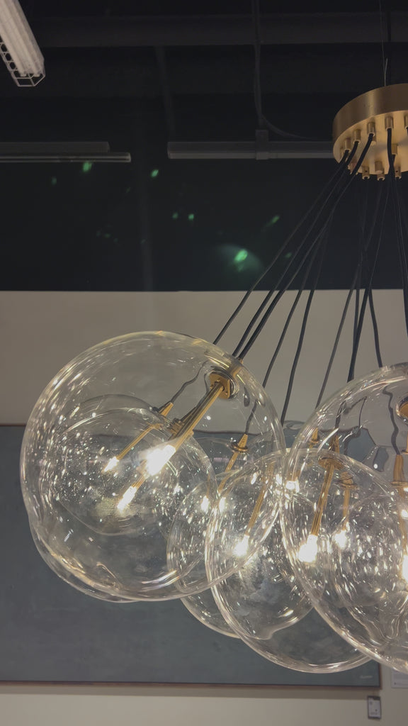 Clear glass bulbs dangle for a statement-making centerpiece. Each globe is individually blown, shaped and sculpted by hand through a one-hour process. Brass and glass are 98% recyclable. Designed and sustainably crafted in Poland by Schwung. Amethyst Home provides interior design, new home construction design consulting, vintage area rugs, and lighting in the Dallas metro area.
