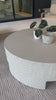 A textured, white concrete coffee table perfect for modern and wabi sabi style.  The table has a matte texture and is perfect for indoors or outdoors.Overall Dimensions: 48.00"w x 48.00"d x 16.25"hWeight : 277.78 lbsMaterials : Concrete Amethyst Home provides interior design, new home construction design consulting, vintage area rugs, and lighting in the Winter Garden metro area.