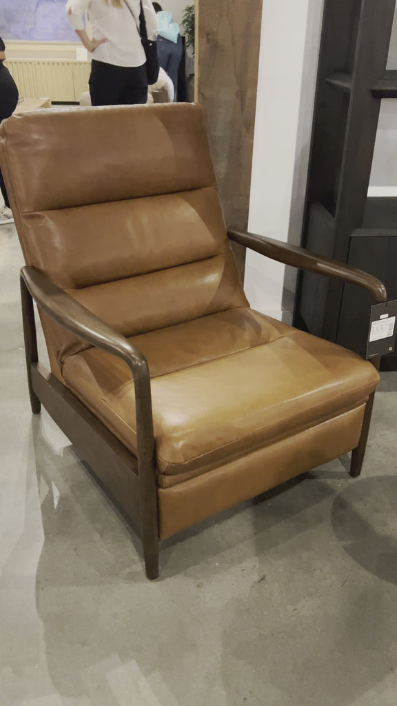 A sleek seat with hidden push-back reclining functionality. This midcentury-inspired recliner features wide chunky channeling paired with slim paddle arms and a tapered wood frame. Designed with a high seat and high back for extra comfy support. Upholstered in a timeless tobacco-hued leather made in a family-owned tannery in Thailand. Amethyst Home provides interior design, new home construction design consulting, vintage area rugs, and lighting in the Calabasas metro area.