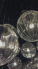 Clear glass spheres float at varying lengths for a statement-making piece. Each globe is individually blown, shaped and sculpted by hand through a one-hour process. The finish on the brass frame is achieved through a specialized process that turns the brass into an almost black hue before the rod is polished smooth. Brass and glass are 98% recyclable. Amethyst Home provides interior design, new home construction design consulting, vintage area rugs, and lighting in the Monterey metro area.