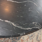 Bring modern style to your home with this black marble and iron round coffee table. Its timeless design will never go out of style. Perfect for entertaining guests or simply decorating your living space.Overall Dimensions: 48"W x 48"L x 15"H Amethyst Home provides interior design, new home construction design consulting, vintage area rugs, and lighting in the Des Moines metro area.