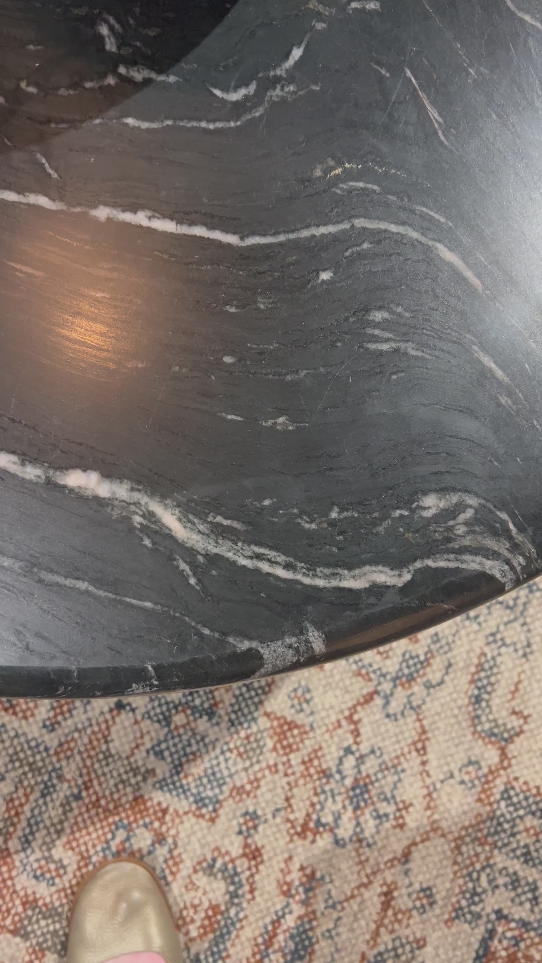 Bring modern style to your home with this black marble and iron round coffee table. Its timeless design will never go out of style. Perfect for entertaining guests or simply decorating your living space.Overall Dimensions: 48"W x 48"L x 15"H Amethyst Home provides interior design, new home construction design consulting, vintage area rugs, and lighting in the Des Moines metro area.