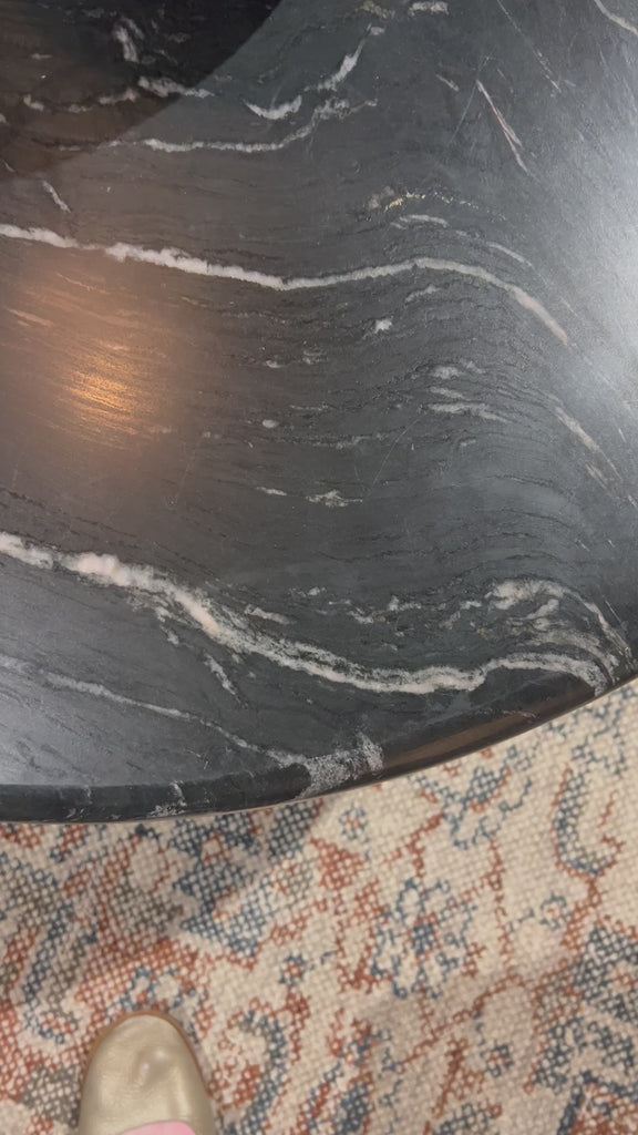 Bring modern style to your home with this black marble and iron round coffee table. Its timeless design will never go out of style. Perfect for entertaining guests or simply decorating your living space.Overall Dimensions: 48"W x 48"L x 15"H Amethyst Home provides interior design, new home construction design consulting, vintage area rugs, and lighting in the Des Moines metro area.