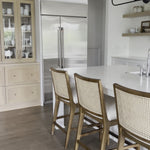 Mixed materials refresh retro stool seating. Light-toasted nettlewood frames a textural inlay of natural cane for a clean, monochromatic look, with a light, linen-blend seat of high-performance fabric brings smart sensibility to bar-style seating. Amethyst Home provides interior design, new home construction design consulting, vintage area rugs, and lighting in the Miami metro area.