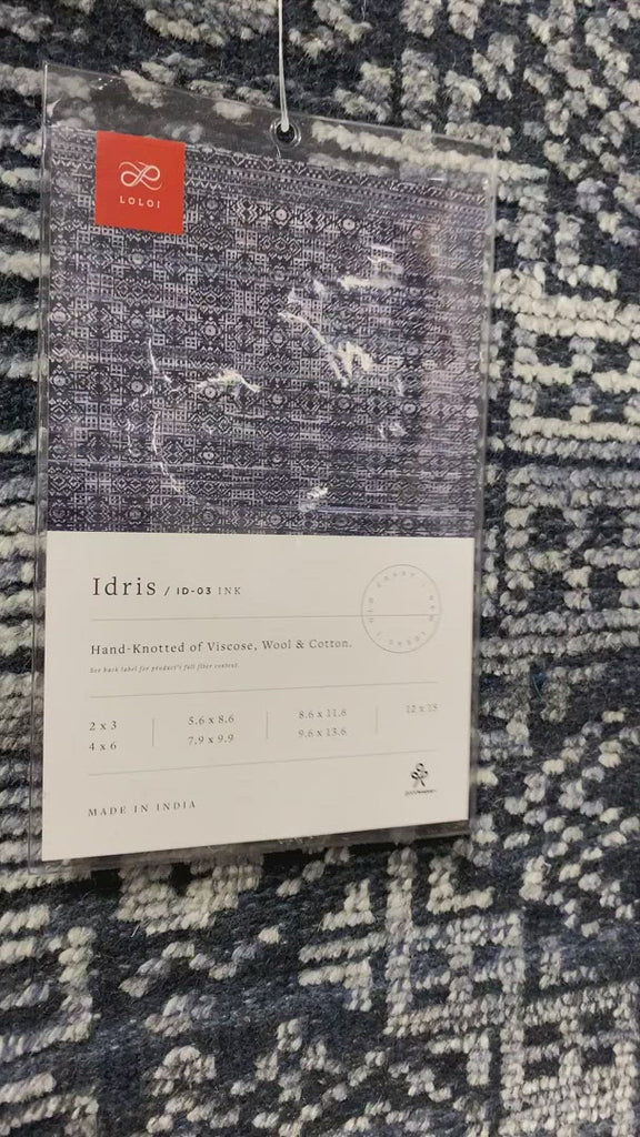 The Idris Ink area rug from Loloi is meticulously hand-knotted of viscose and wool. You will love this rug because the rug is:  Perfect for entryways, living rooms, and bedrooms Easy to clean and maintain Gorgeous with the intricate pattern and patina Warms up any room with the high / low pile Hand-Knotted 70% Viscose | 30% Wool ID-03 Ink