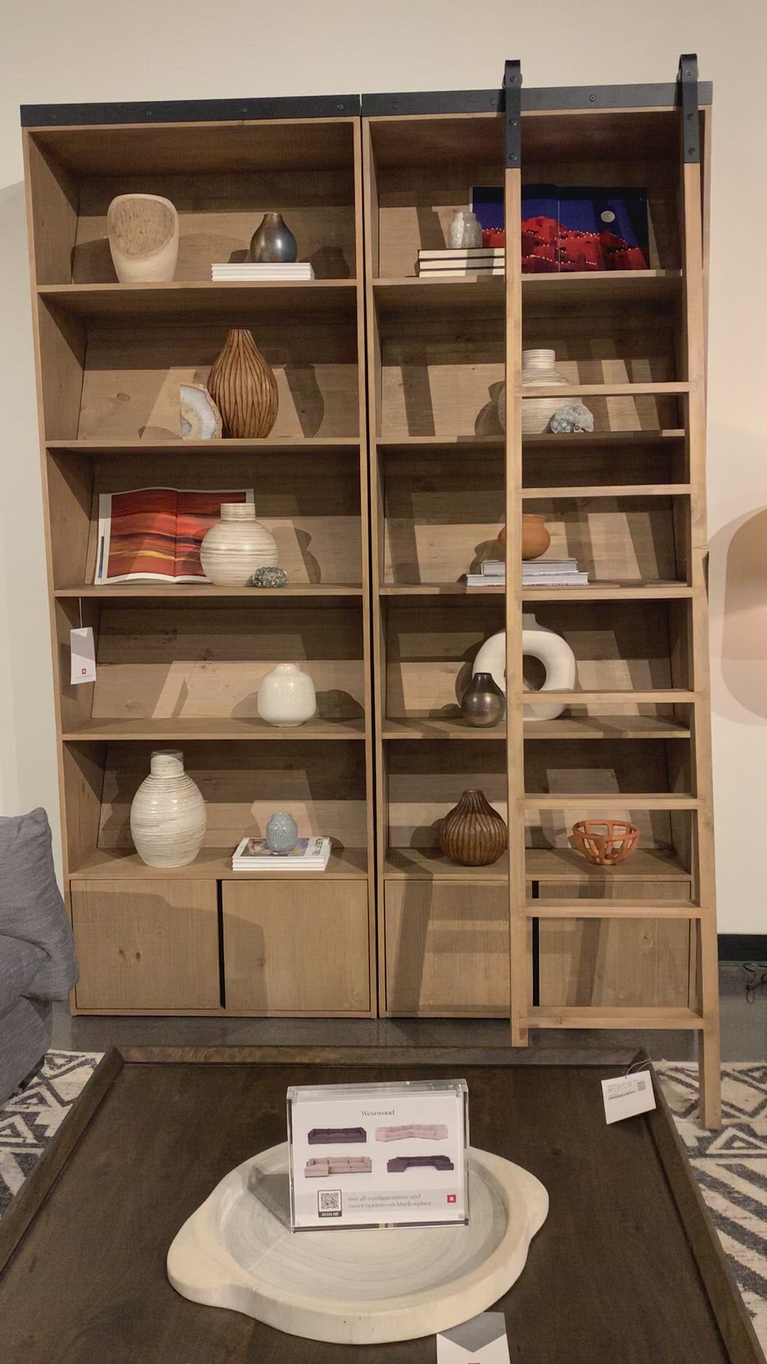 Load video: Five roomy shelves are ready to store favorite books and treasures, with smoked solid pine suited for any space. Removable ledges slant at an angle on each shelf, for even-better display of art and coffee table-size books, plus an optional slide ladder (for decorative use only) to complete the look.  Overall Dimensions: 35.50&quot;w x 17.50&quot;d x 98&quot;h