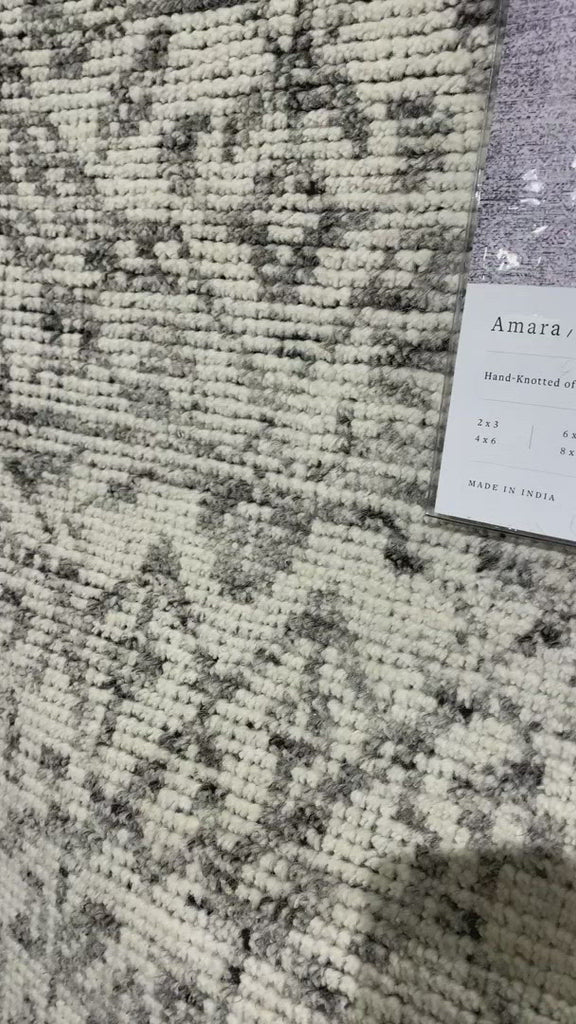 Hand-knotted in India of 100% wool, the Amara Ivory/Taupe Area Rug creates a casual yet refined vibe with high-end appeal. With shades of ivory, taupe, and black, this is a gorgeous rug to showcase in your living room, entryway, bedroom, or other high traffic area.   Hand Knotted 100% Wool AMM-04 Ivory/Taupe
