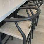 Modern curves redefine the classic wishbone-style of this Muestra Black Teak Counter + Bar Stool. Vintage white all-weather wicker is woven for a dose of fresh texture within weathered grey teak framing. Cover or store indoors during inclement weather and when not in use.
