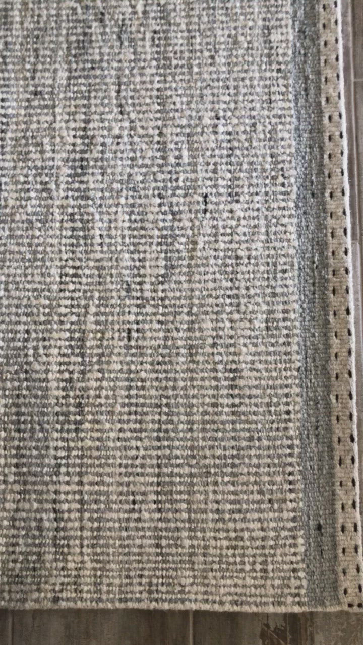 Load video: A perfect blend of refined and relaxed, the Sloane Collection is hand-woven of wool, cotton and polyester by artisans in India. Sloane offers a sophisticated foundation for a contemporarily bohemian look with perfectly woven stripes and minimalist appeal.  Hand Woven 79% Wool | 10% Cotton | 8% Polyester | 3% Other Fibers SLN-01 Mist