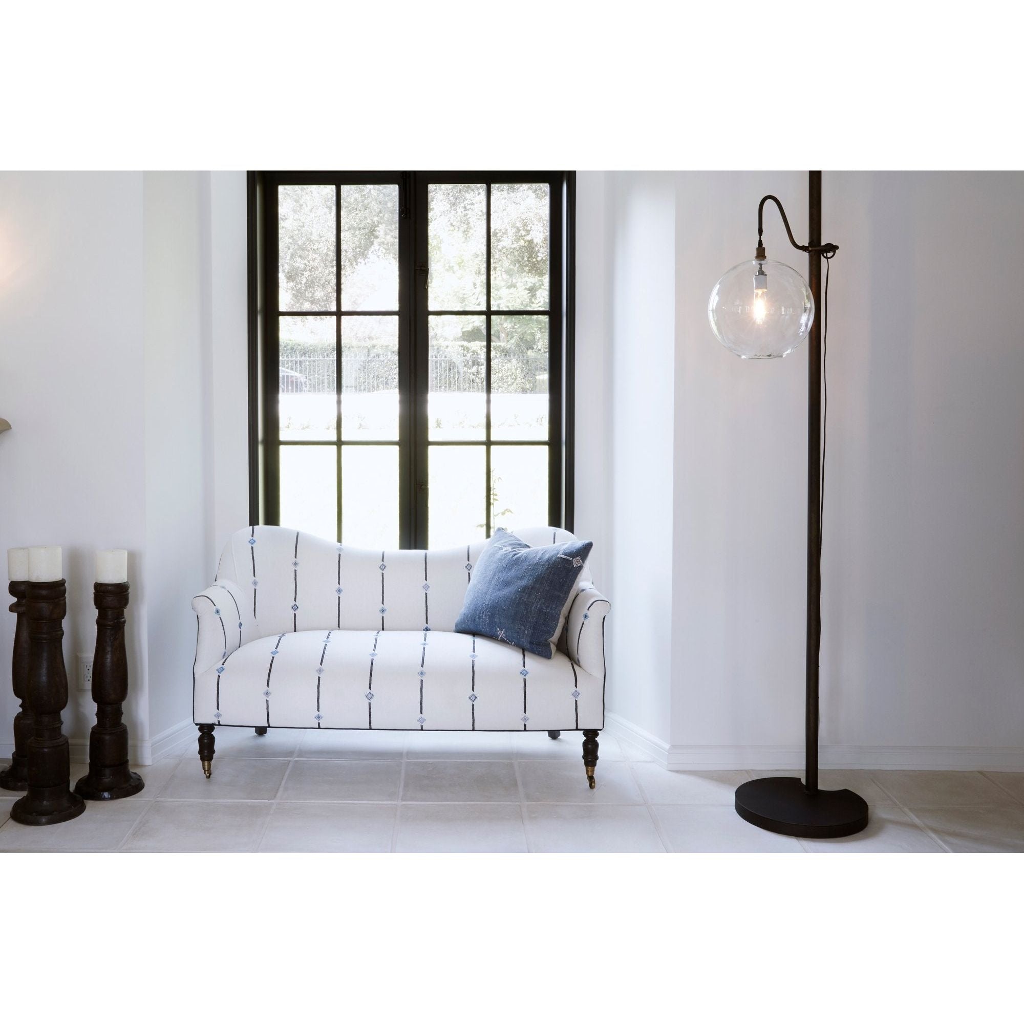 The Aurora Lamp from Cisco Brothers adds a chic light to any room. Each lamp is hand blown glass and can vary up to 1" in size. The light fixture can be height adjusted upon the metal rod to fit right where you need it. The lamp can come in a globe, bailey medium lamp, or bailey small lamp.