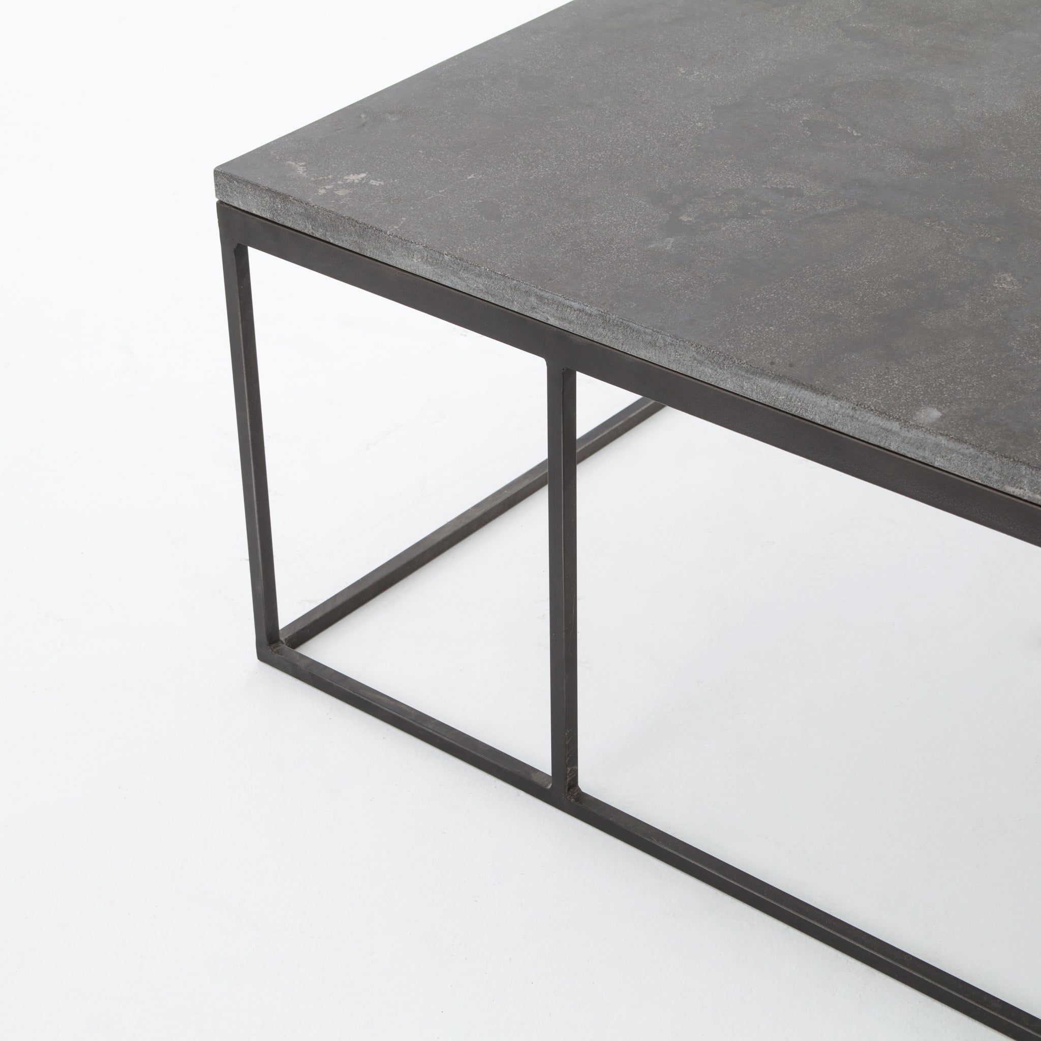 Spare beauty, casual elegance with the Harlow Bluestone Small Coffee Table. A gunmetal Parson's base with hand-rubbed, dimensional edges supports a rough-hewn bluestone slab that feels found and perfectly placed.  Size: 60"w x 28"d x 17"h Materials: Iron, Limestone