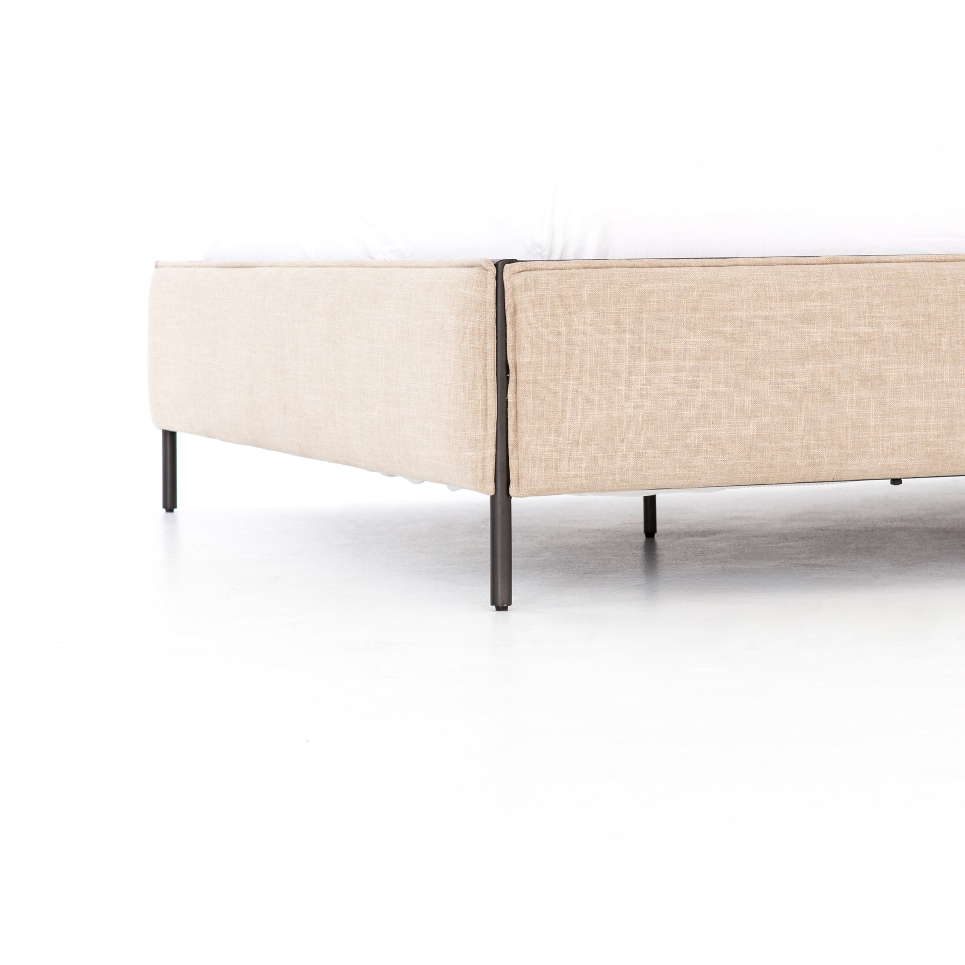 Safari styling gets a modern reboot with this Leigh Upholstered Bed. Linen-blend upholstery of neutral taupe lays a texture-rich base for a forward-thinking bedroom look. Brown leather straps secure decorative headboard pillows, suspended for eye-catching effect. Box spring required.