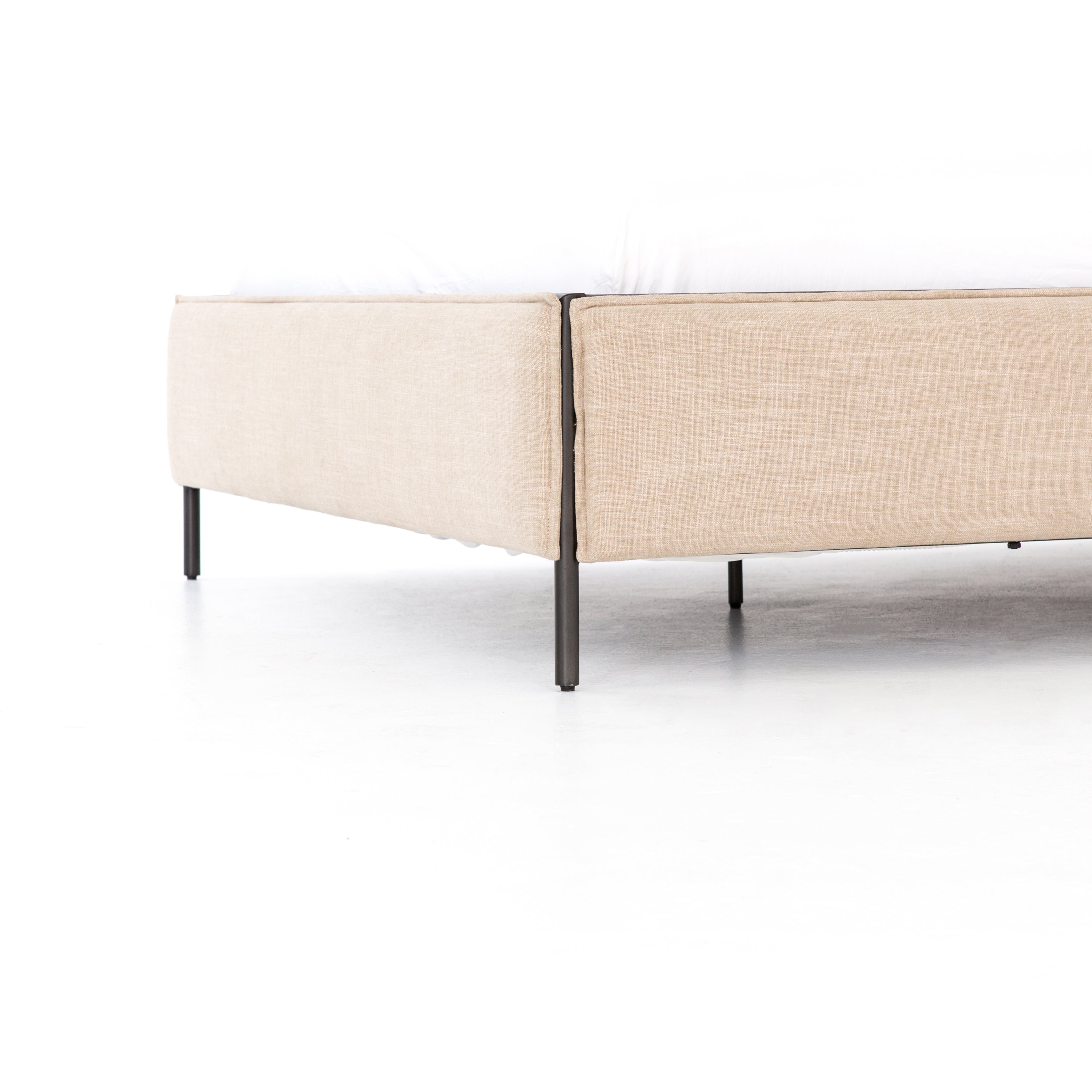 Safari styling gets a modern reboot with this Leigh Upholstered Bed. Linen-blend upholstery of neutral taupe lays a texture-rich base for a forward-thinking bedroom look. Brown leather straps secure decorative headboard pillows, suspended for eye-catching effect. Box spring required.