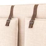 Safari styling gets a modern reboot with this Leigh Upholstered Bed. Linen-blend upholstery of neutral taupe lays a texture-rich base for a forward-thinking bedroom look. Brown leather straps secure decorative headboard pillows, suspended for eye-catching effect. Box spring required.