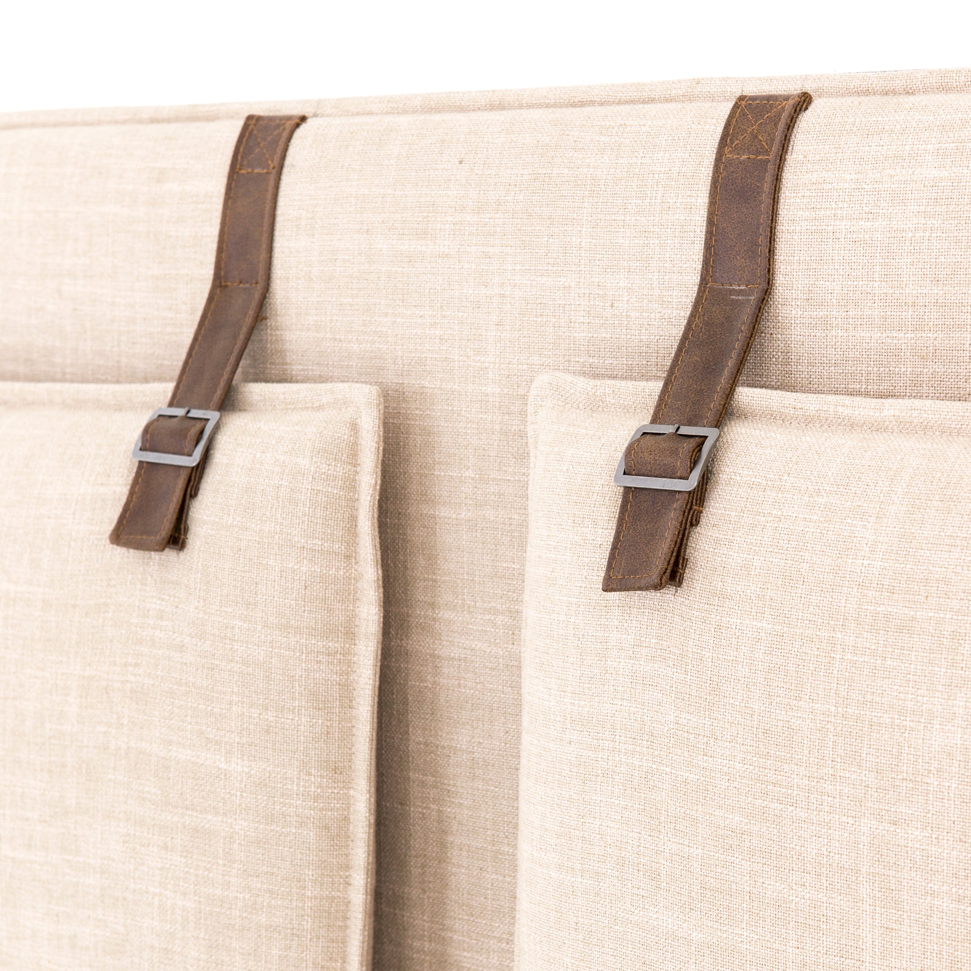 Safari styling gets a modern reboot with this Leigh Upholstered Bed. Linen-blend upholstery of neutral taupe lays a texture-rich base for a forward-thinking bedroom look. Brown leather straps secure decorative headboard pillows, suspended for eye-catching effect. Box spring required.