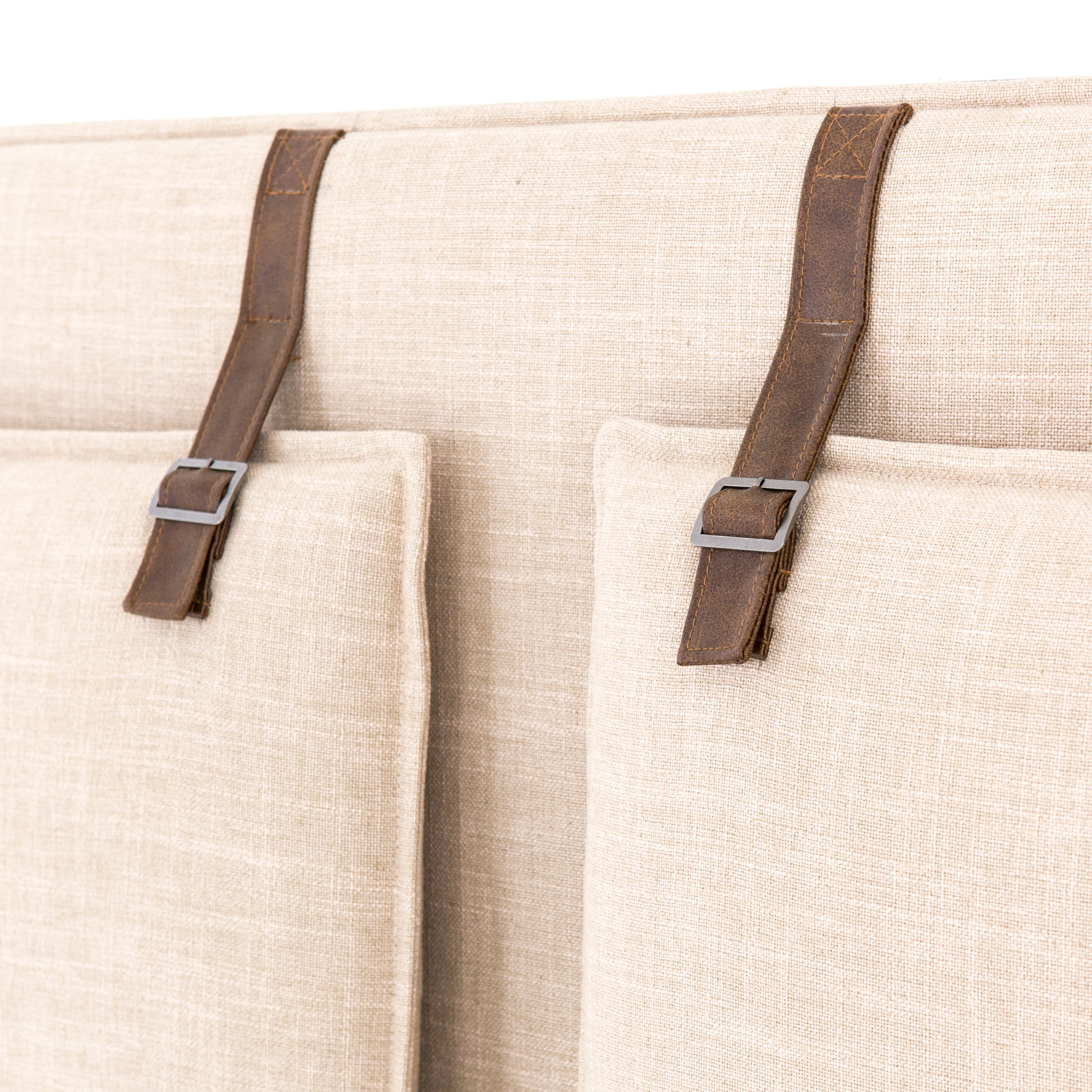Safari styling gets a modern reboot with this Leigh Upholstered Bed. Linen-blend upholstery of neutral taupe lays a texture-rich base for a forward-thinking bedroom look. Brown leather straps secure decorative headboard pillows, suspended for eye-catching effect. Box spring required.
