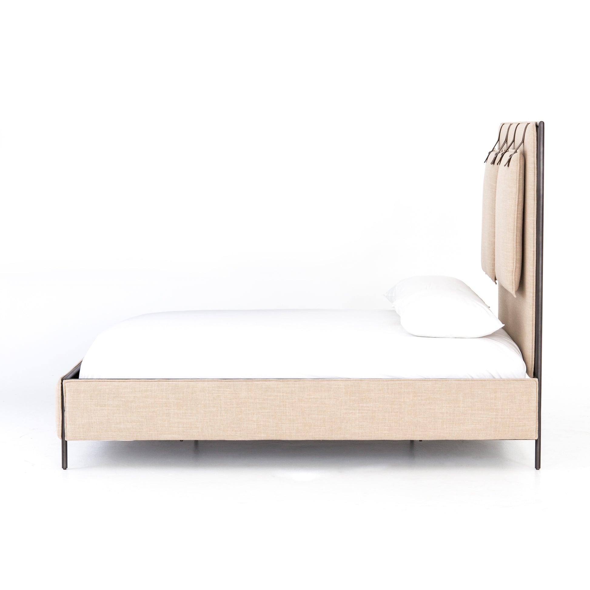 Safari styling gets a modern reboot with this Leigh Upholstered Bed. Linen-blend upholstery of neutral taupe lays a texture-rich base for a forward-thinking bedroom look. Brown leather straps secure decorative headboard pillows, suspended for eye-catching effect. Box spring required.
