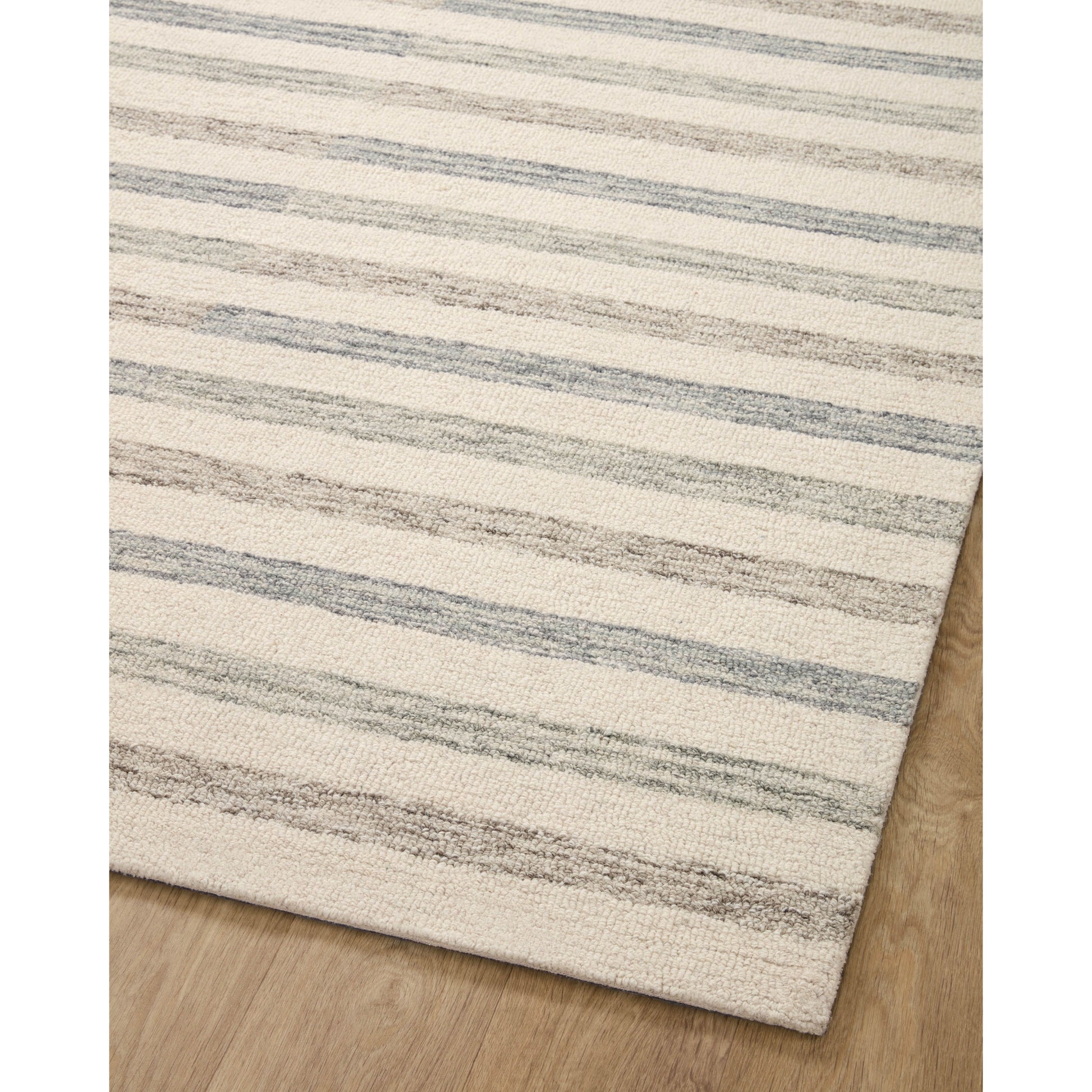 Known for its durability, the Chris Ivory / Slate hooked wool rug is a smart choice for any room in your home that gets lots of love. The subtle, tonal stripes remind us of our favorite California cool hemp rugs. Amethyst Home provides interior design services, furniture, rugs, and lighting in the Austin metro area.