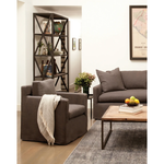 The Louis Chair by Cisco Brothers has an engaging profile and a sheltering, narrow seat. This design combines modern and coastal aesthetics with clean lines, a straight skirt, and a subtle 2" slit. A classic style with a scale that suits any living room or lounge area. Photographed in Logan Oatmeal. Lifestyle in Logan Grey. 