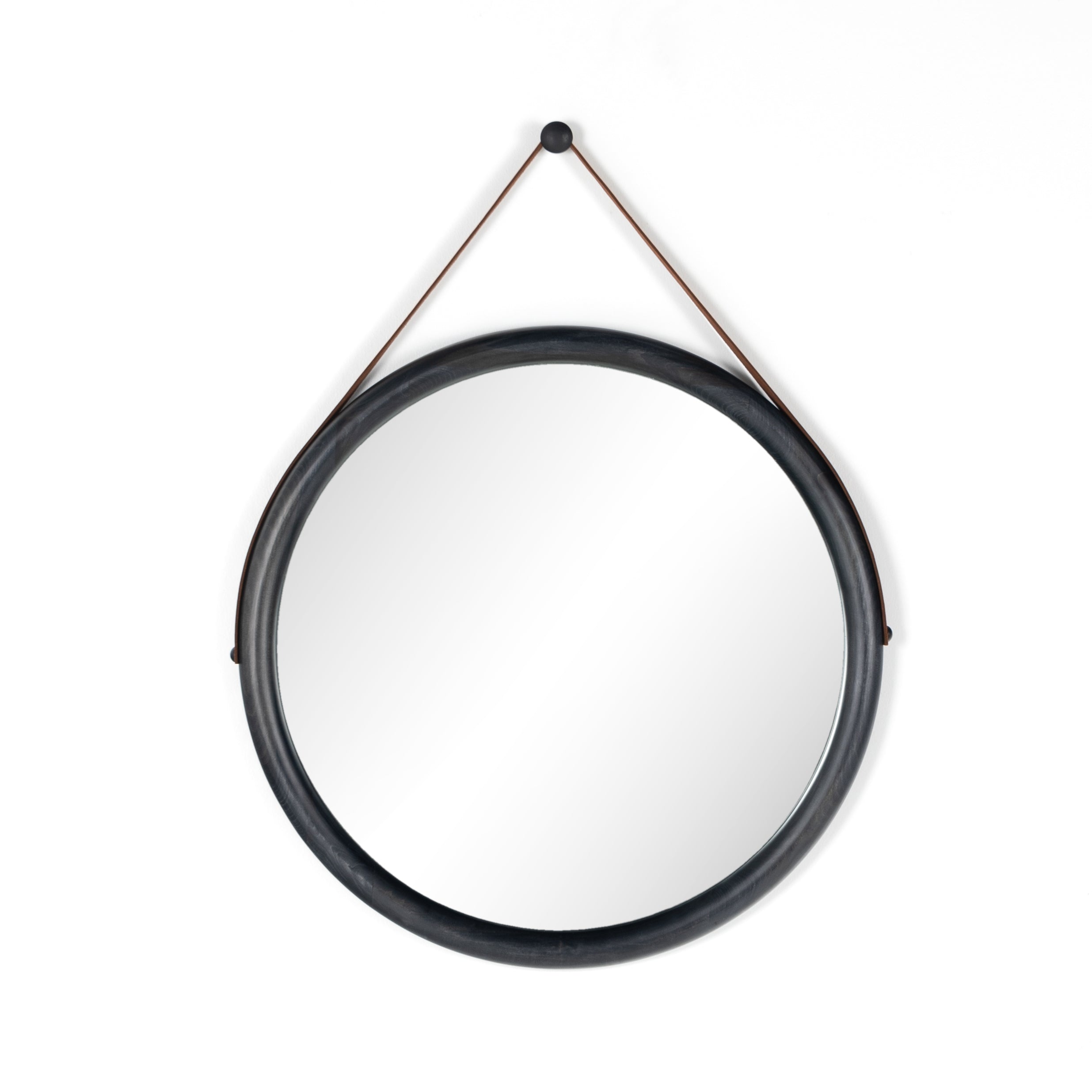 The Des Mirror is hung by a handsome, toffee-colored top grain leather strap. We love the fresh take on what would otherwise be a traditional, round mirror. The mirror is framed in black-washed popular and would like amazing hung in an entryway, bedroom, or other space.   Overall Dimensions: 30.00"w x 1.50"d x 30.00"h Colors: Natural Iron, Black Wash Poplar, Toffee Leather Materials: Iron, Solid Poplar, Top Grain Leather  Please allow 3-4 weeks on shipment for these items. 