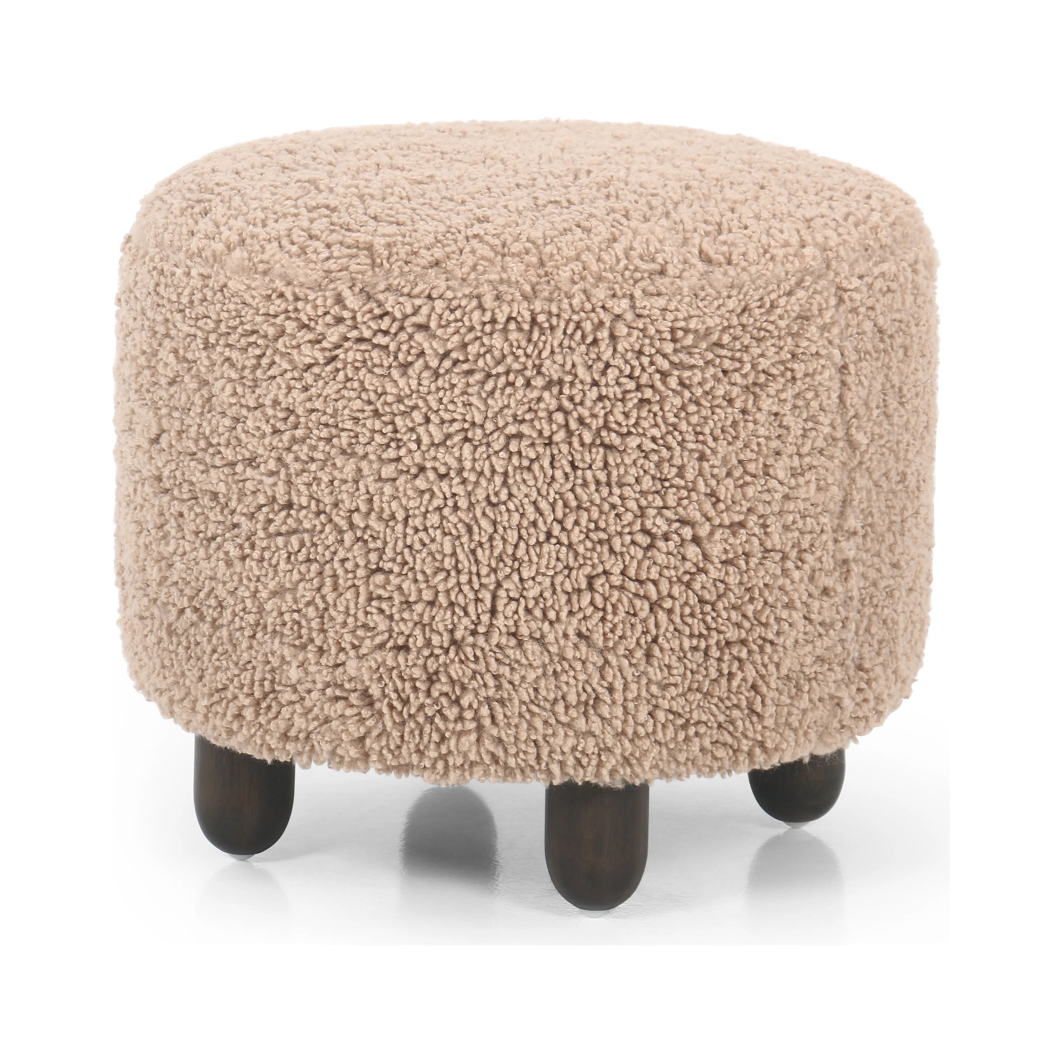 Place this round ottoman just about anywhere. Upholstered in a faux Mongolian shearling with a high pile fur in a toasty tan neutral hue. Burnt birch parawood legs add a touch of contrast.Collection: Kensingto Amethyst Home provides interior design, new home construction design consulting, vintage area rugs, and lighting in the Austin metro area.