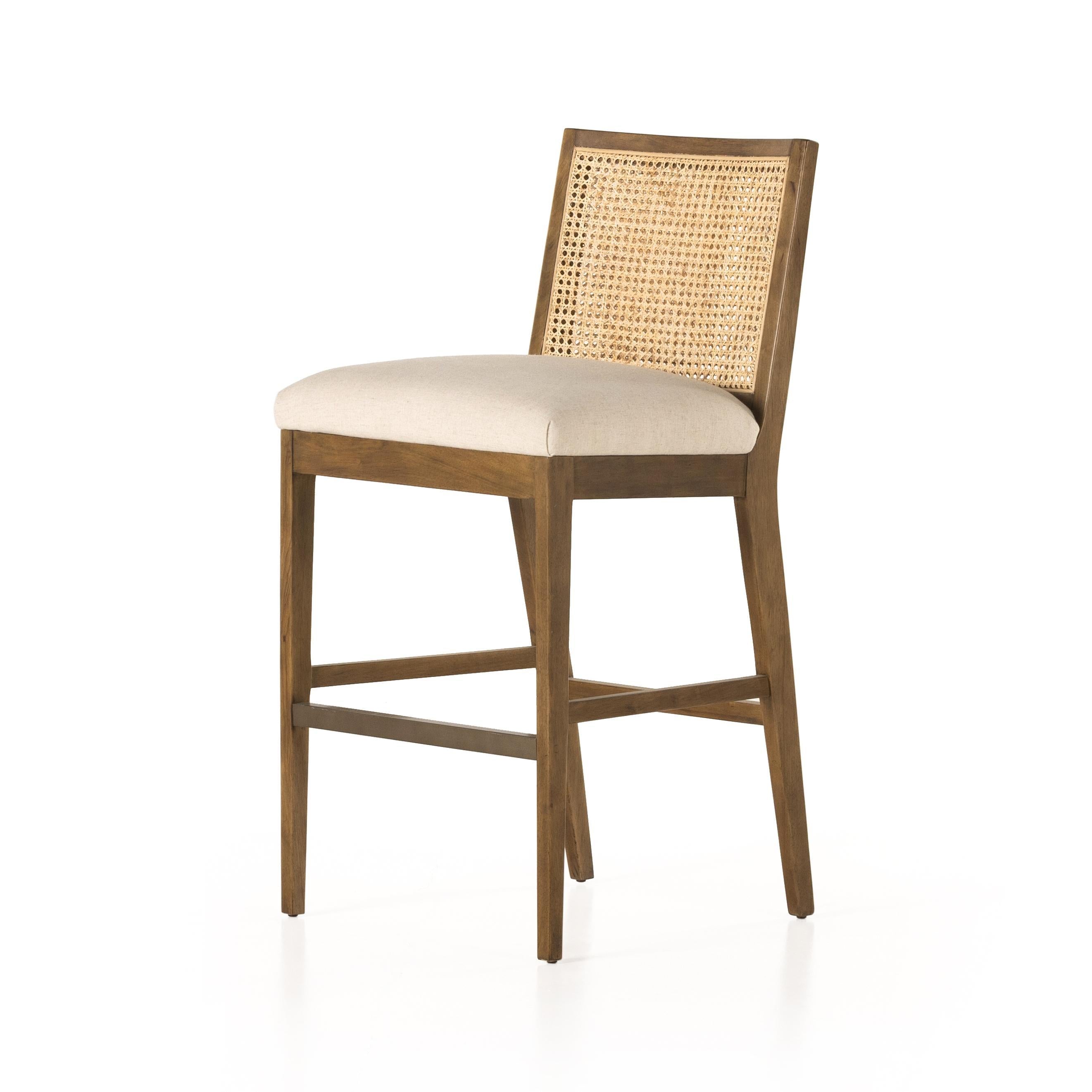 Mixed materials refresh retro stool seating. Light-toasted nettlewood frames a textural inlay of natural cane for a clean, monochromatic look, with a light, linen-blend seat of high-performance fabric brings smart sensibility to bar-style seating. Amethyst Home provides interior design, new home construction design consulting, vintage area rugs, and lighting in the Alpharetta metro area.