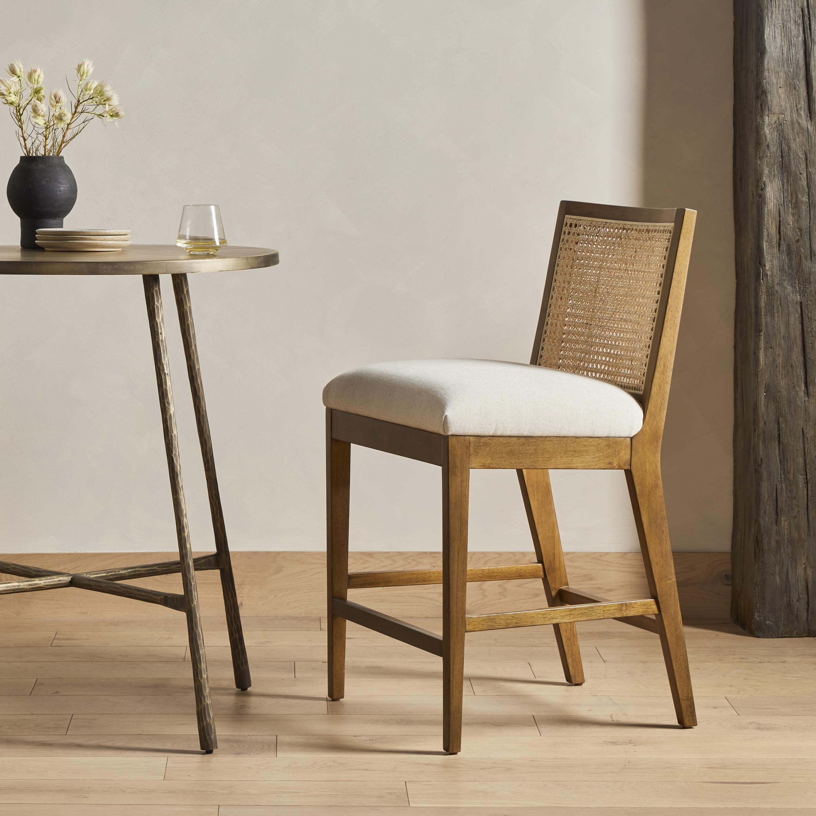 Mixed materials refresh retro stool seating. Light-toasted nettlewood frames a textural inlay of natural cane for a clean, monochromatic look, with a light, linen-blend seat of high-performance fabric brings smart sensibility to bar-style seating. Amethyst Home provides interior design, new home construction design consulting, vintage area rugs, and lighting in the Park City metro area.