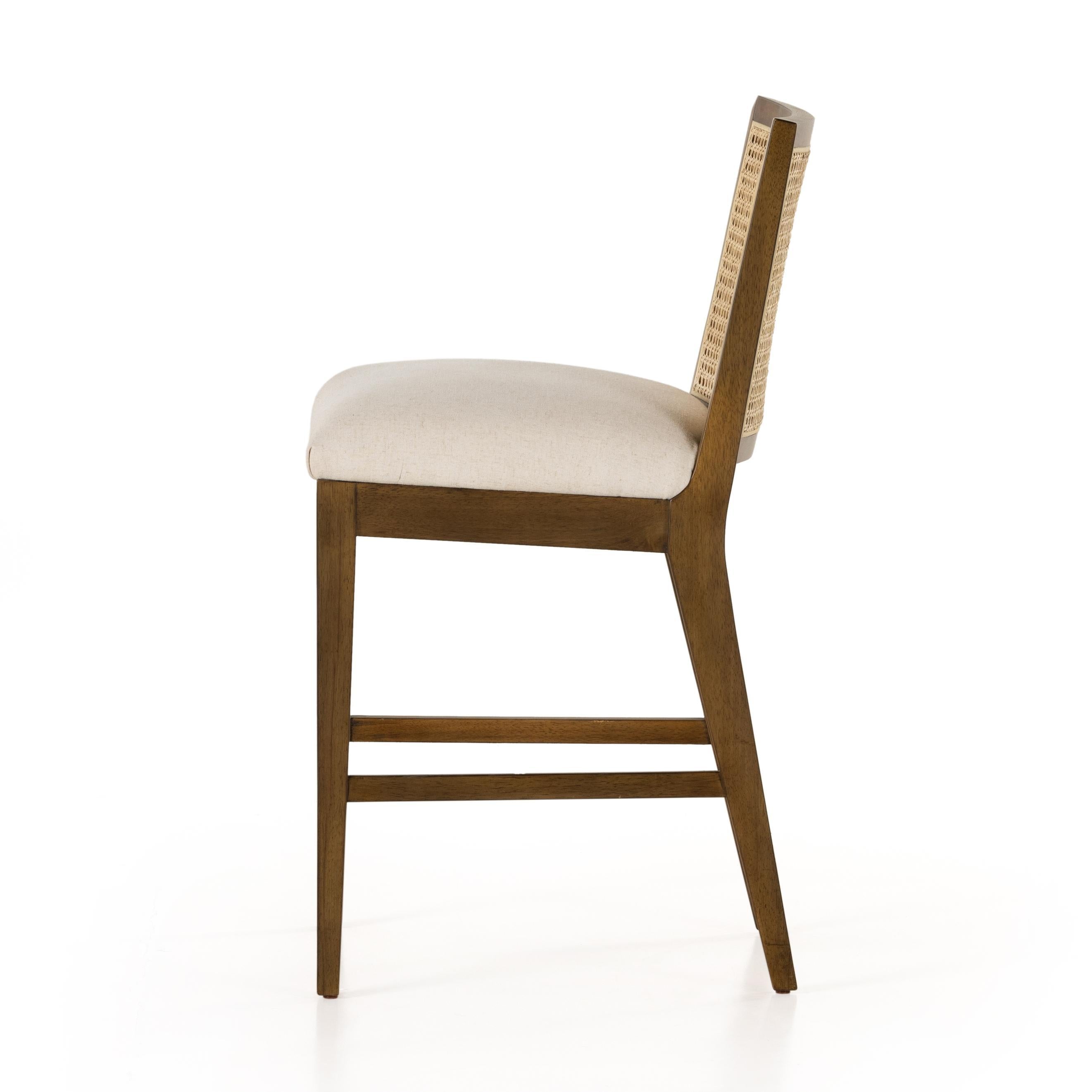 Mixed materials refresh retro stool seating. Light-toasted nettlewood frames a textural inlay of natural cane for a clean, monochromatic look, with a light, linen-blend seat of high-performance fabric brings smart sensibility to bar-style seating. Amethyst Home provides interior design, new home construction design consulting, vintage area rugs, and lighting in the San Diego metro area.