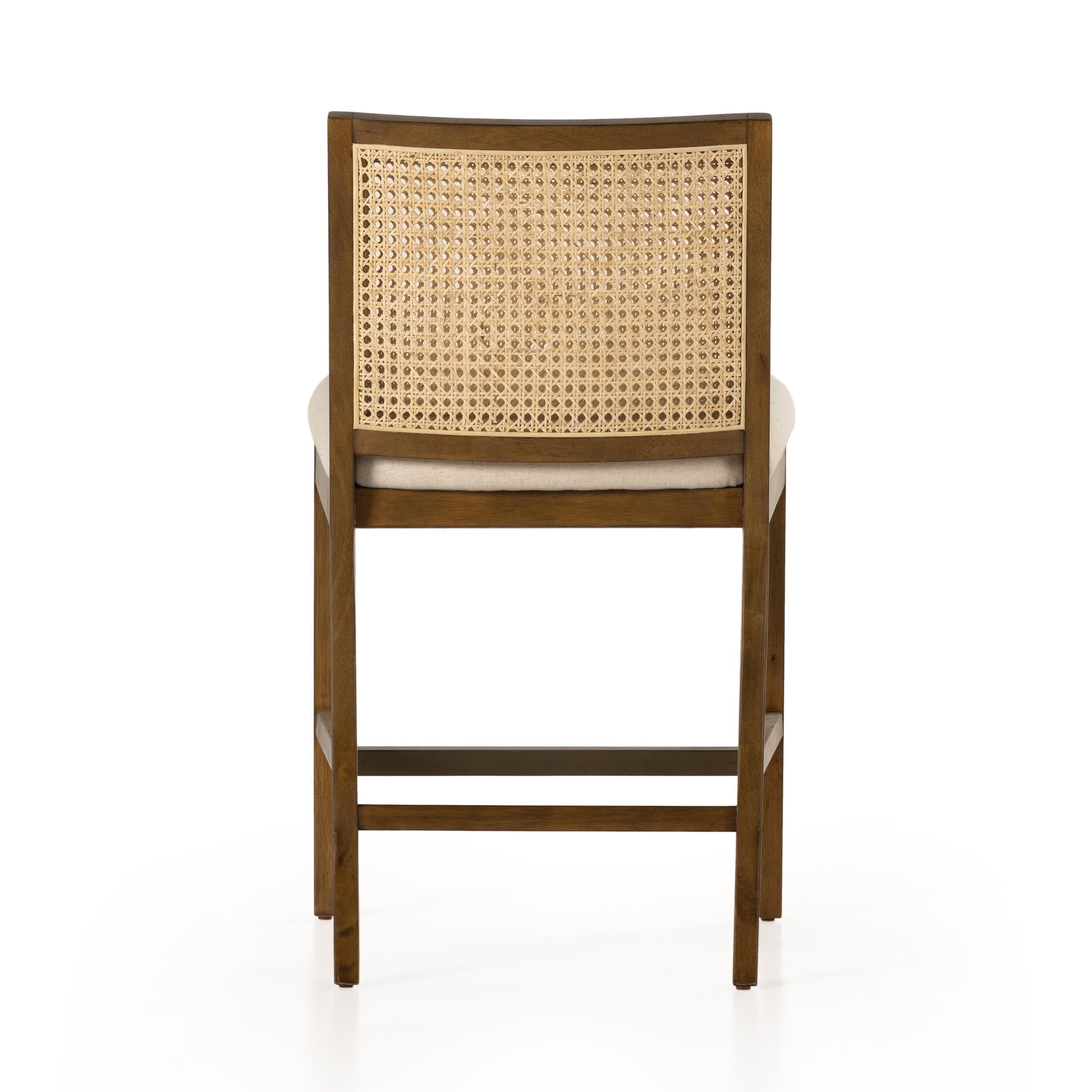 Mixed materials refresh retro stool seating. Light-toasted nettlewood frames a textural inlay of natural cane for a clean, monochromatic look, with a light, linen-blend seat of high-performance fabric brings smart sensibility to bar-style seating. Amethyst Home provides interior design, new home construction design consulting, vintage area rugs, and lighting in the Tampa metro area.