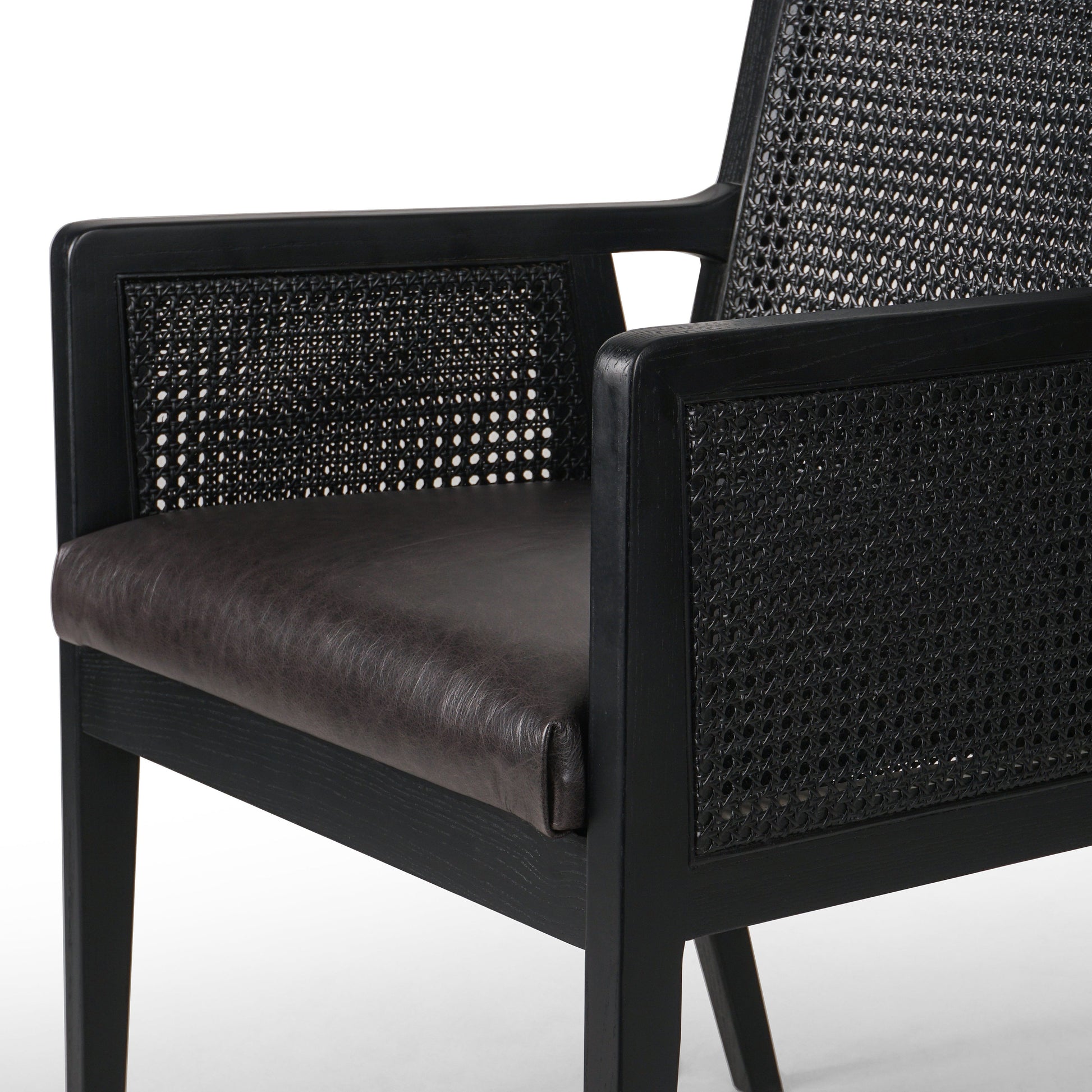 Ebony-brushed parawood frames a textural cane inlay, with top-grain leather seating in a chic black. Amethyst Home provides interior design, new construction, custom furniture, and area rugs in the Houston metro area.