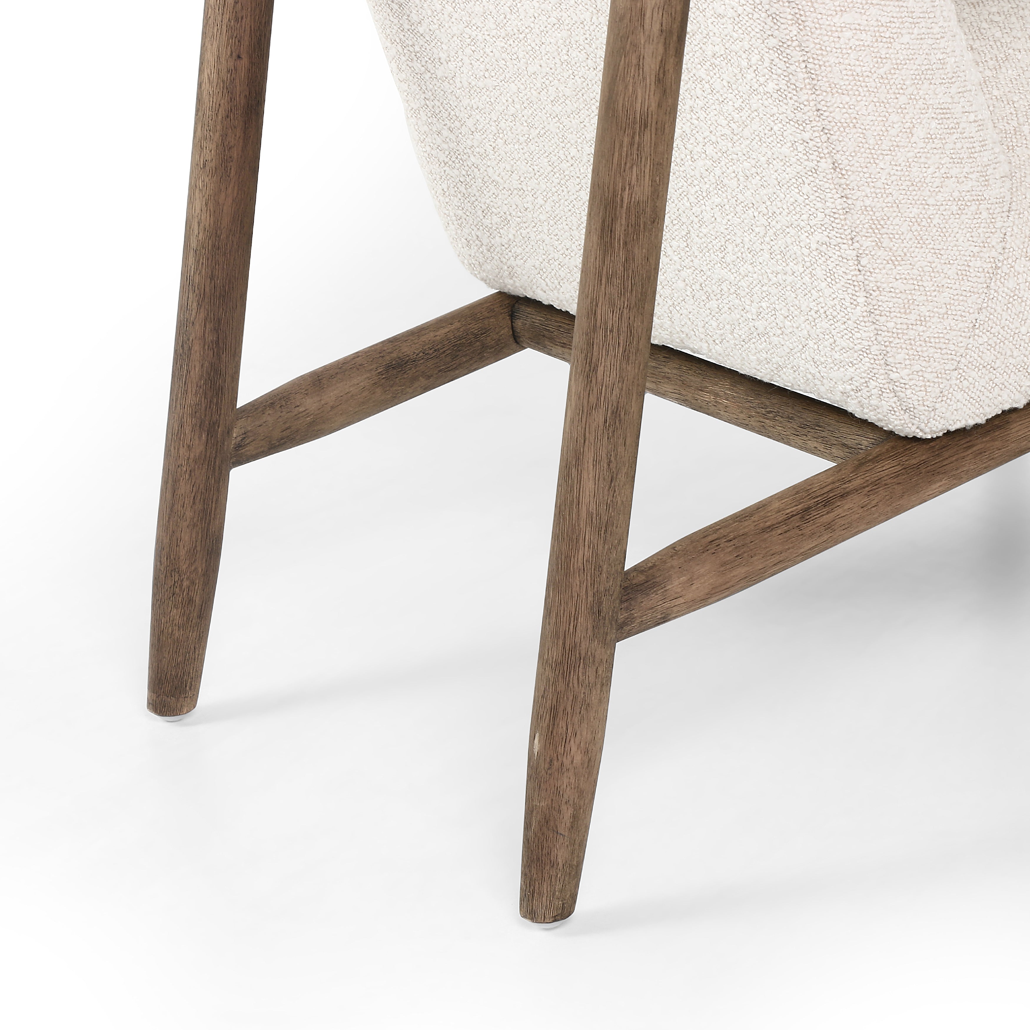 Featuring Arnett Chair by Four Hands at Amethyst Home. Textural cream boucle seating offers a sumptuous sit, with complementary wire-brushed parawood framing forming a slim U shape. Two posterior top-grain leather straps add a stylish finishing touch. Performance fabrics are specially created to withstand spills, stains, high traffic and wear, ensuring long-term comfort and unmatc. Amethyst Home provides interior design, new construction, custom furniture and area rugs in the Des Moines metro area
