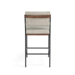 Simple and streamlined with fresh, thoughtful details. Slim, black-finished round stock iron suspends an almond-finished nettlewood deck, with a flannel-colored linen-blend seat and floating back with a rear wooden stretcher. Amethyst Home provides interior design services, furniture, rugs, and lighting in the Dallas metro area.