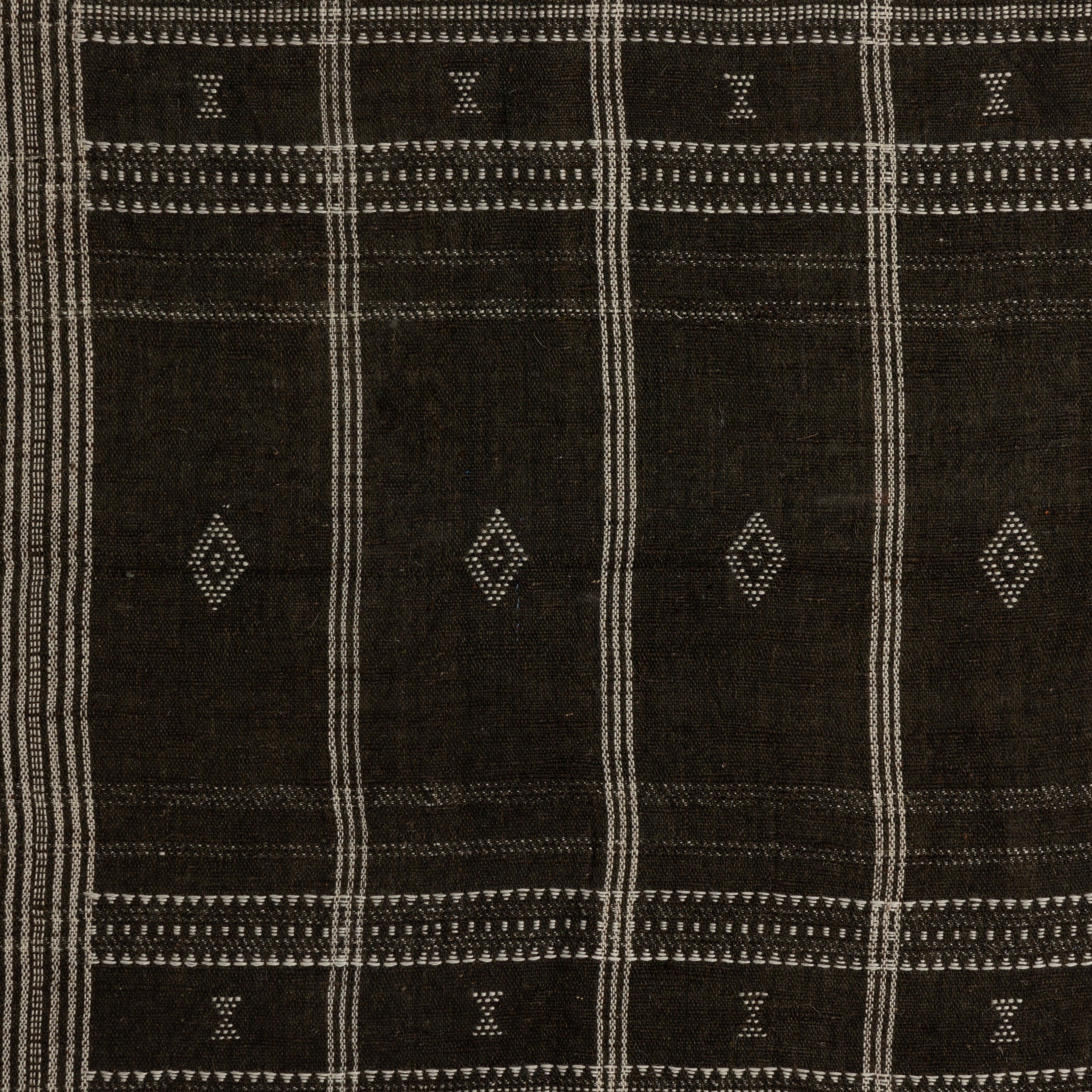 Featuring Bhujodi Chocolate With Rustic Walnut Textile by Four Hands at Amethyst Home. A 500-year-old tradition comes to life on this 100% wool, handwoven textile. Crafted on a traditional frame loom following a tradition created by the Vankars of the Bhujodi village in India, a process that can take up to two days to complete. Finished with fringe tassel. Amethyst Home provides interior design, new home construction design consulting, vintage area rugs, and lighting in the Los Angeles metro area.