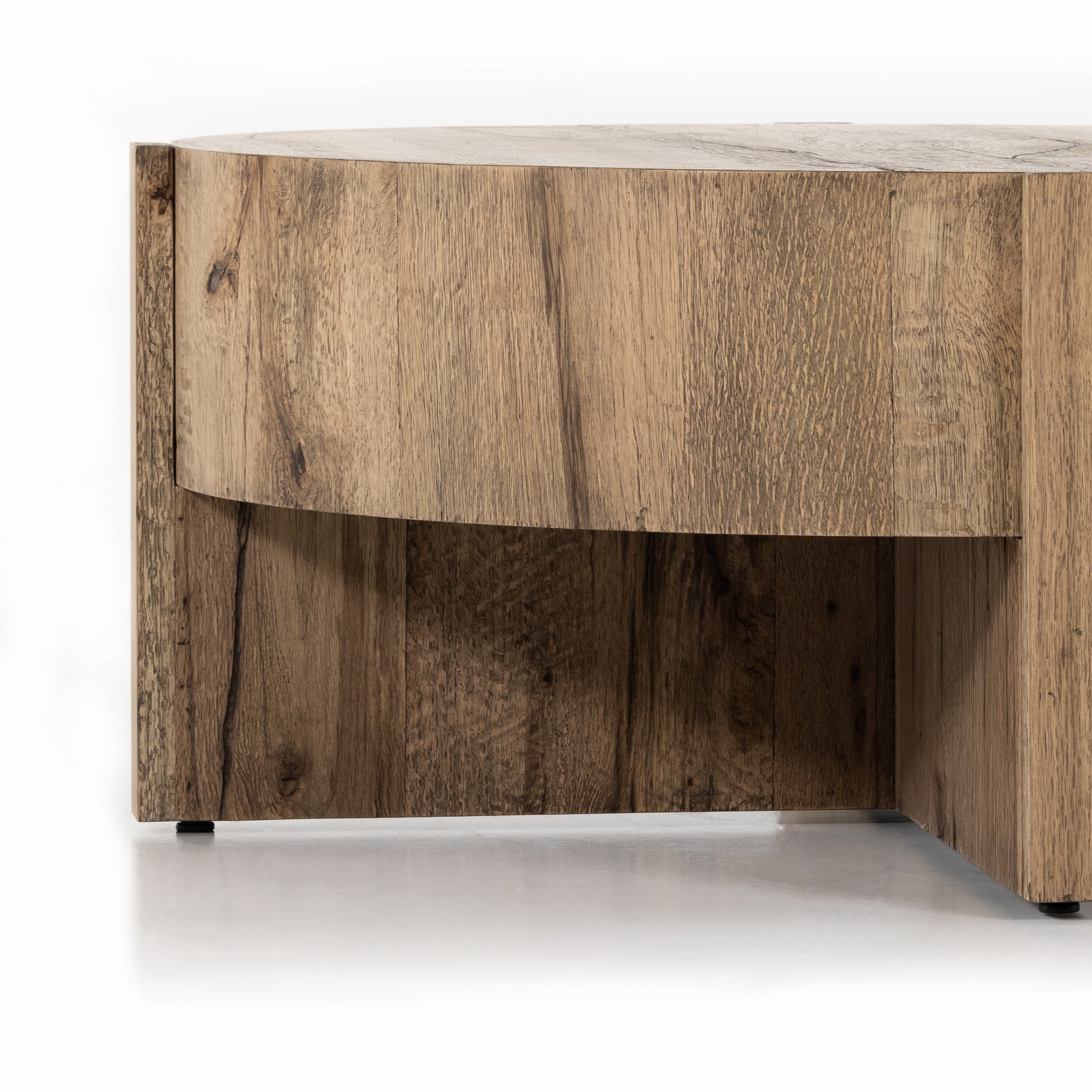 An organic-spirited statement piece. A drum-style coffee table of character-rich oak and veneers rests within a sculptural cradle base of matching rustic oak with beautiful highs and lows. Amethyst Home provides interior design, new construction, custom furniture, and area rugs in the Charlotte metro area.