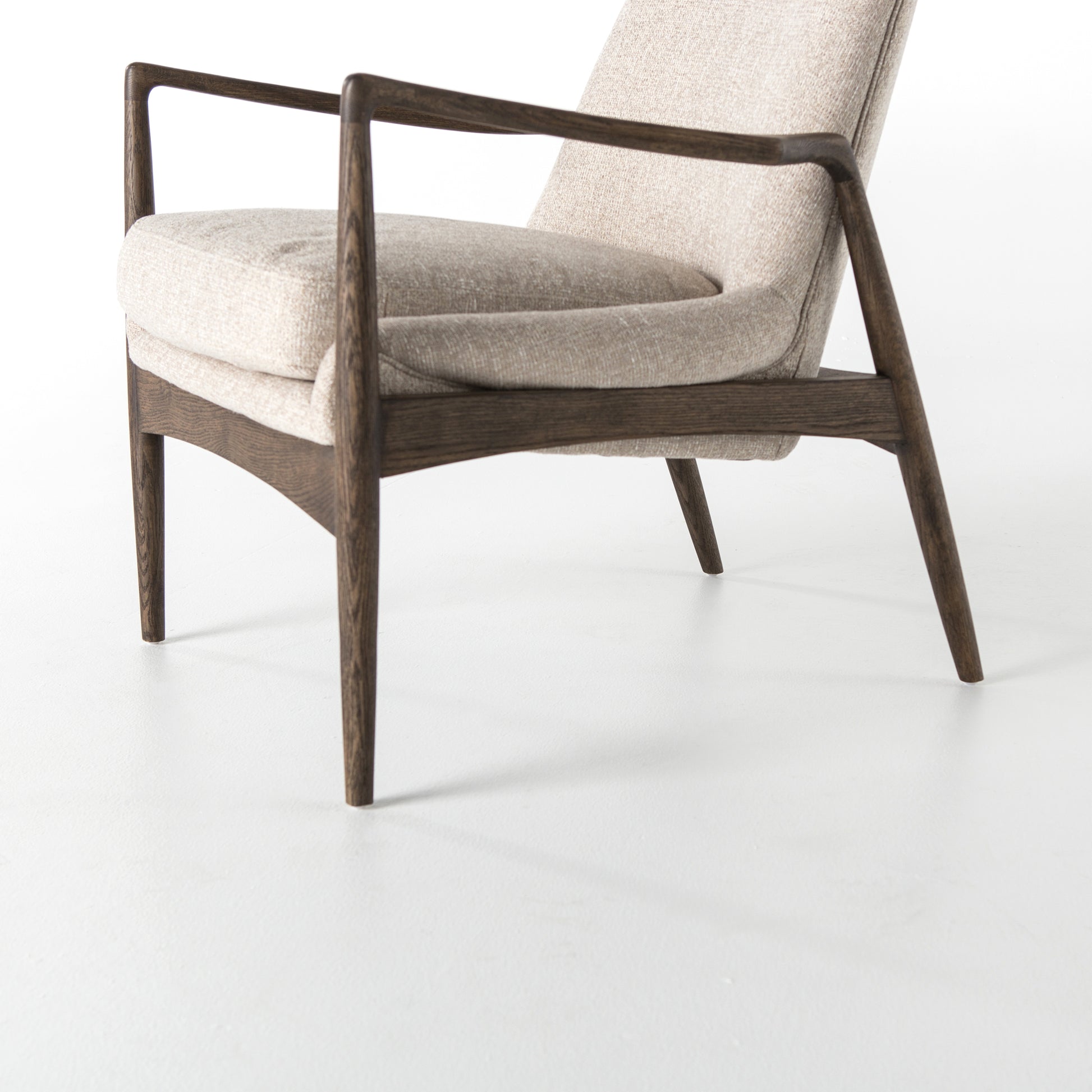 Dramatic arms and a deeper seat offer relaxation with mid-century modern sophistication. Sculpted frame adds an architectural feel to light camel upholstery. Amethyst Home provides interior design, new construction, custom furniture, and area rugs in the Miami metro area.