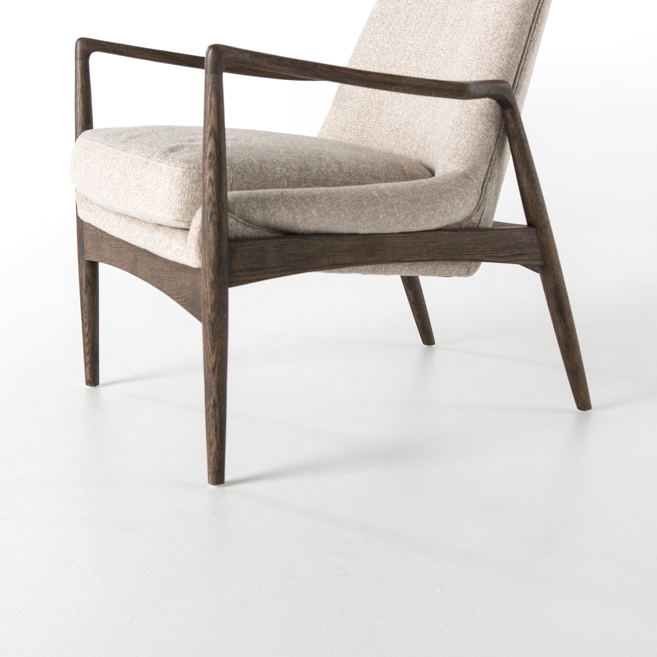 Dramatic arms and a deeper seat offer relaxation with mid-century modern sophistication. Sculpted frame adds an architectural feel to light camel upholstery. Amethyst Home provides interior design, new construction, custom furniture, and area rugs in the Miami metro area.