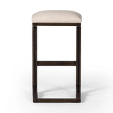 Featuring Finn Sienna Brown Oak Bar Stool by Four Hands at Amethyst Home. A stunner from every angle, this architecturally inspired stool features an angular base crafted from solid oak with two iron rods for added support and visual interest. Seat is upholstered in a linen/cotton/poly blend performance fabric with subtle texture throughout. Performance fabric. Amethyst Home provides interior design, new home construction design consulting, vintage area rugs, and lighting in the Dallas metro area.
