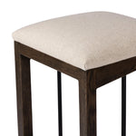 Featuring Finn Sienna Brown Oak Bar Stool by Four Hands at Amethyst Home. A stunner from every angle, this architecturally inspired stool features an angular base crafted from solid oak with two iron rods for added support and visual interest. Seat is upholstered in a linen/cotton/poly blend performance fabric with subtle texture throughout. Performance fab. Amethyst Home provides interior design, new home construction design consulting, vintage area rugs, and lighting in the San Diego metro area.
