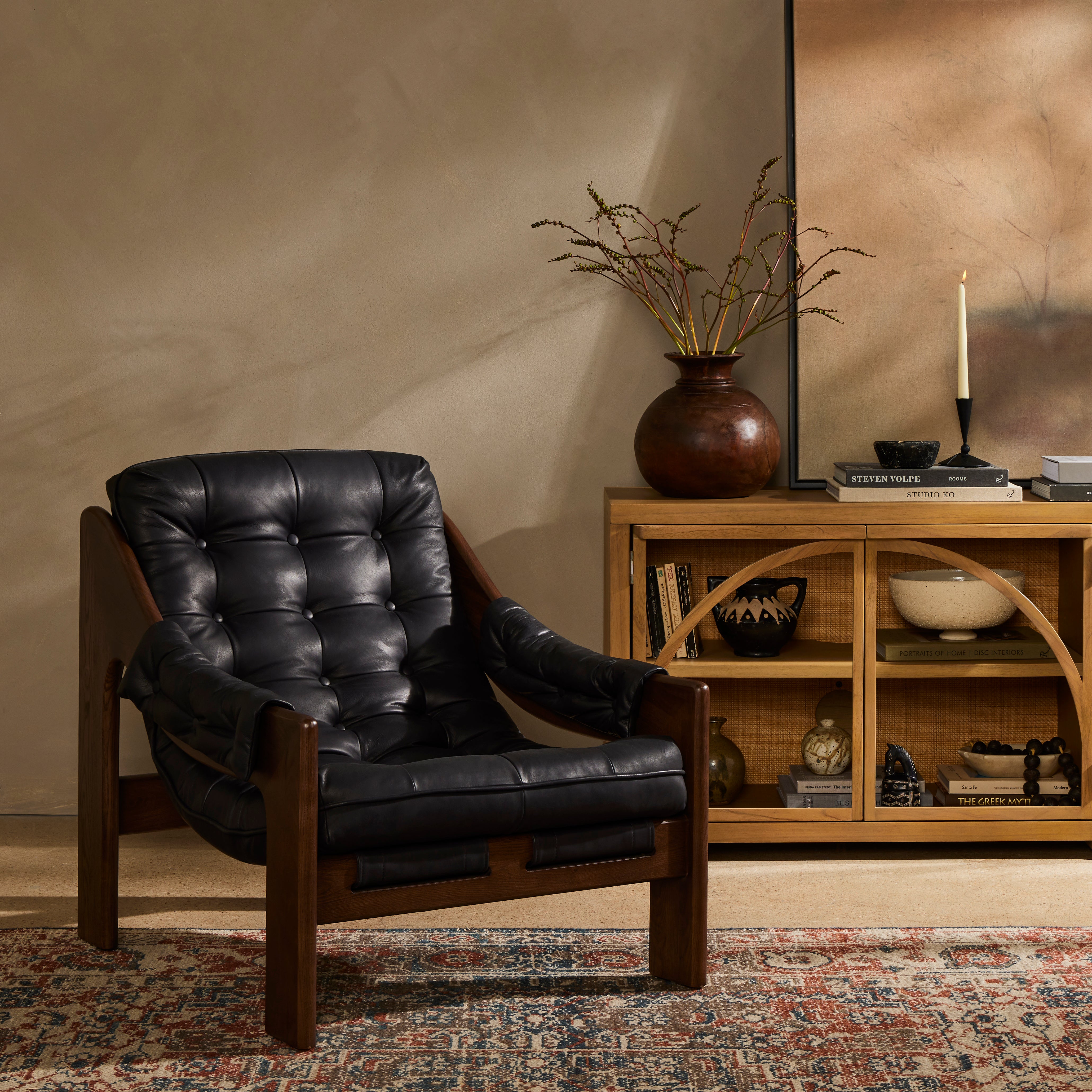 A Seventies-era style inspired by a flea market find, a dramatically tufted sling seat of black top-grain leather angles at the just-right pitch for total comfort, with wide, brown ash framing. Amethyst Home provides interior design, new home construction design consulting, vintage area rugs, and lighting in the Laguna Beach metro area.