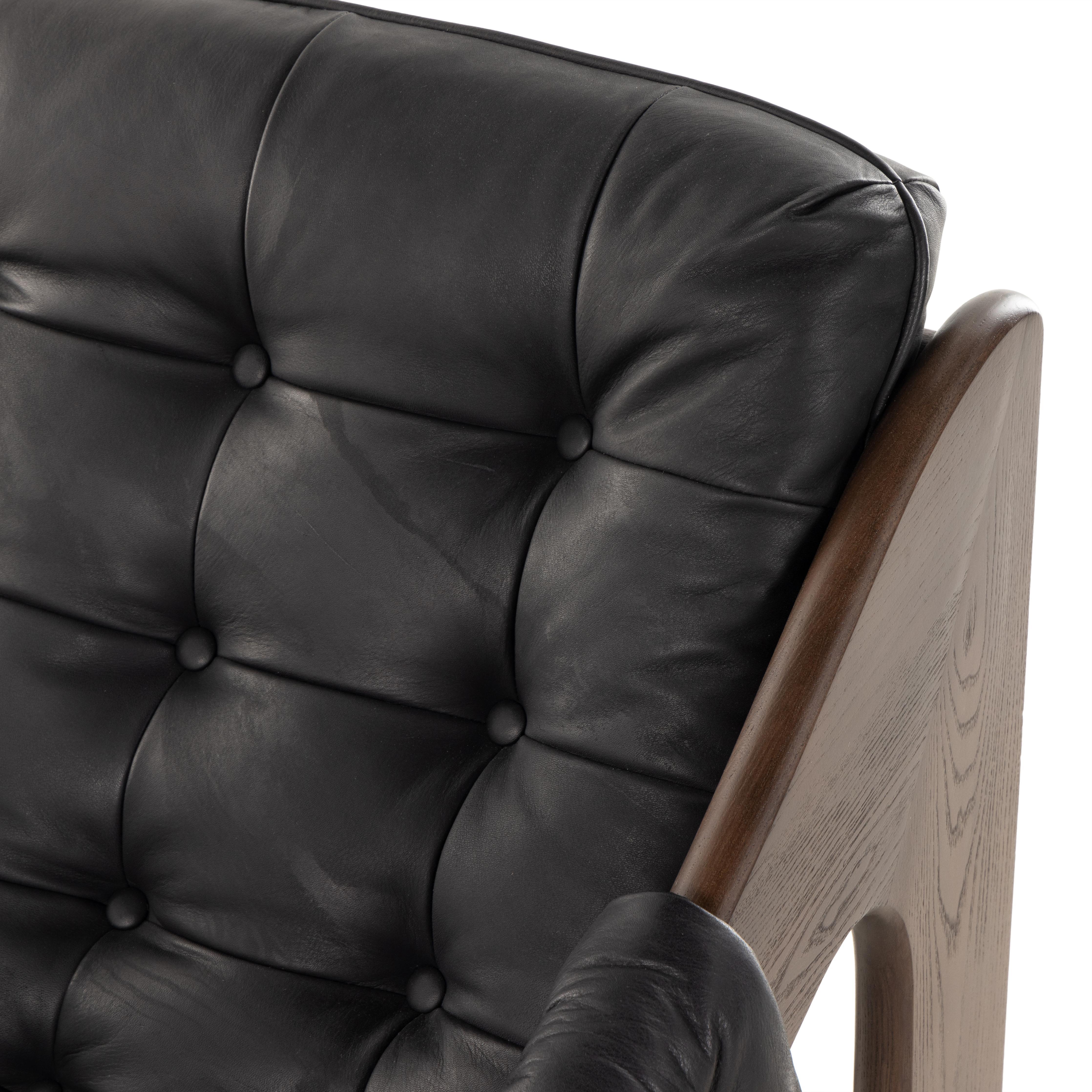 A Seventies-era style inspired by a flea market find, a dramatically tufted sling seat of black top-grain leather angles at the just-right pitch for total comfort, with wide, brown ash framing. Amethyst Home provides interior design, new home construction design consulting, vintage area rugs, and lighting in the Park City metro area.