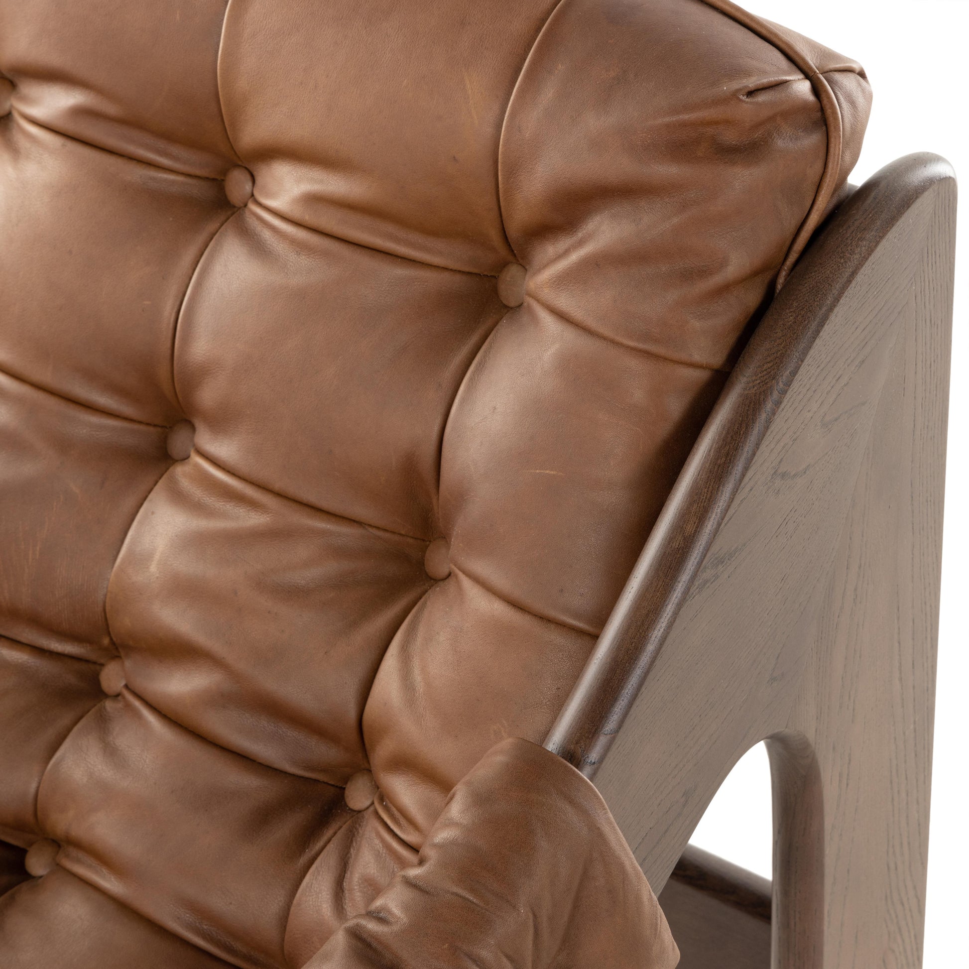 A Seventies-era style inspired by a flea market find, a dramatically tufted sling seat of black top-grain leather angles at the just-right pitch for total comfort, with wide, brown ash framing. Amethyst Home provides interior design, new home construction design consulting, vintage area rugs, and lighting in the Park City metro area.