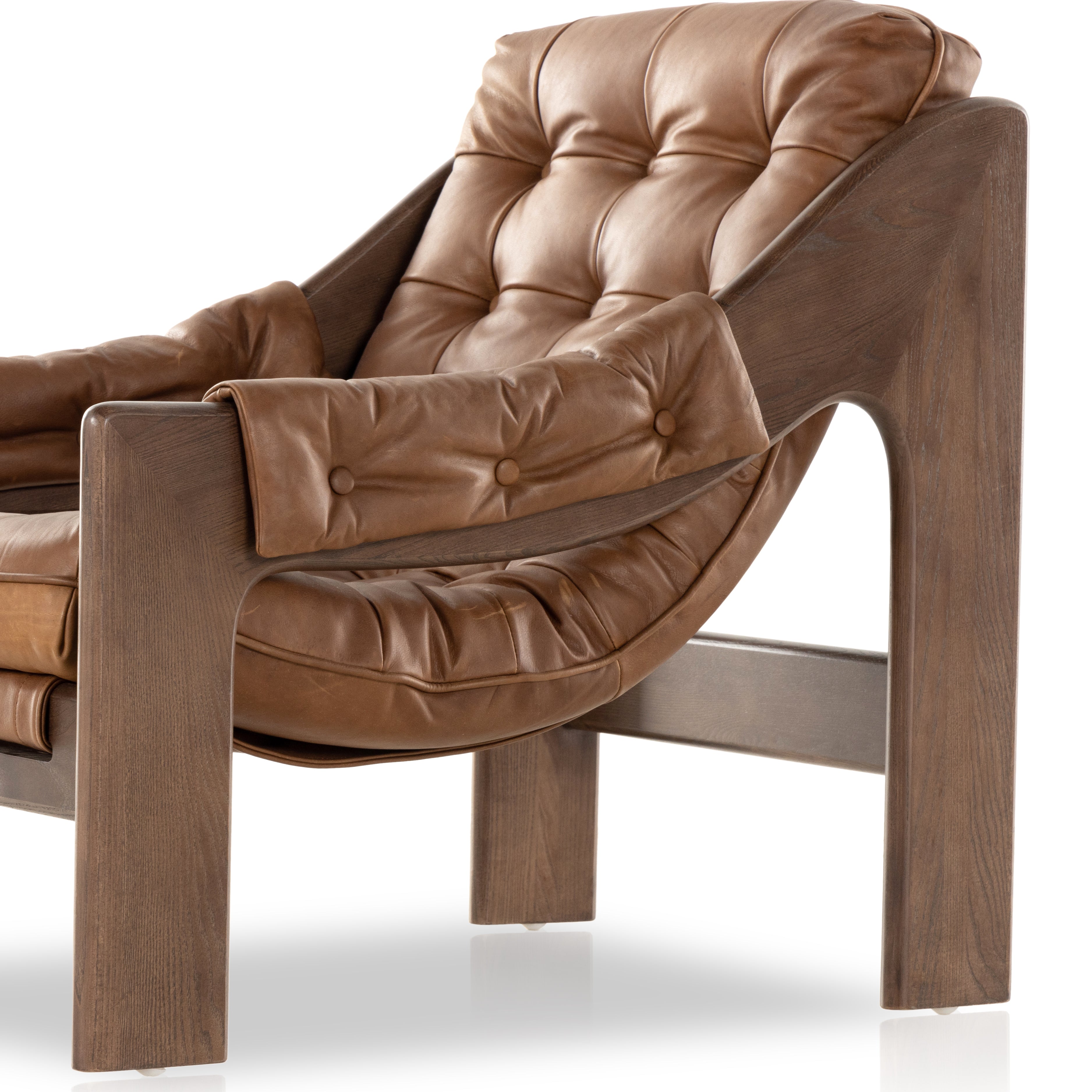 A Seventies-era style inspired by a flea market find, a dramatically tufted sling seat of black top-grain leather angles at the just-right pitch for total comfort, with wide, brown ash framing. Amethyst Home provides interior design, new home construction design consulting, vintage area rugs, and lighting in the Salt Lake City metro area.