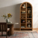 Ilana Burnished Mindi Cabinet forms a dramatic arch this glass-front cabinetry, with woven natural cane backing for a textural finishing touch. Amethyst Home provides interior design services, furniture, rugs, and lighting in the Omaha metro area.