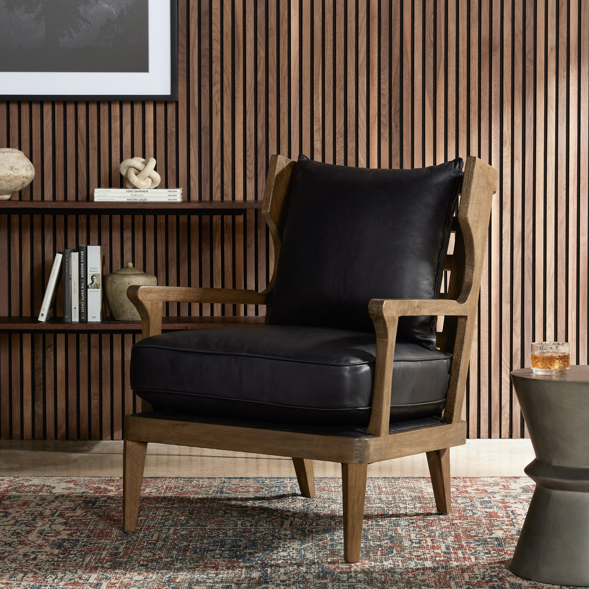 A solid frame of warm oak features a high, ladder back design for a regal air. Upholstered in heirloom black leather. Sourced from one of the oldest family-owned tanneries in Italyâ€™s Bassano del Grappa, heirloom leather is salvaged and processed from upcycled hides featuring an abundance of natural markings, scars and color variations. Amethyst Home provides interior design, new construction, custom furniture, and area rugs in the Omaha metro area.