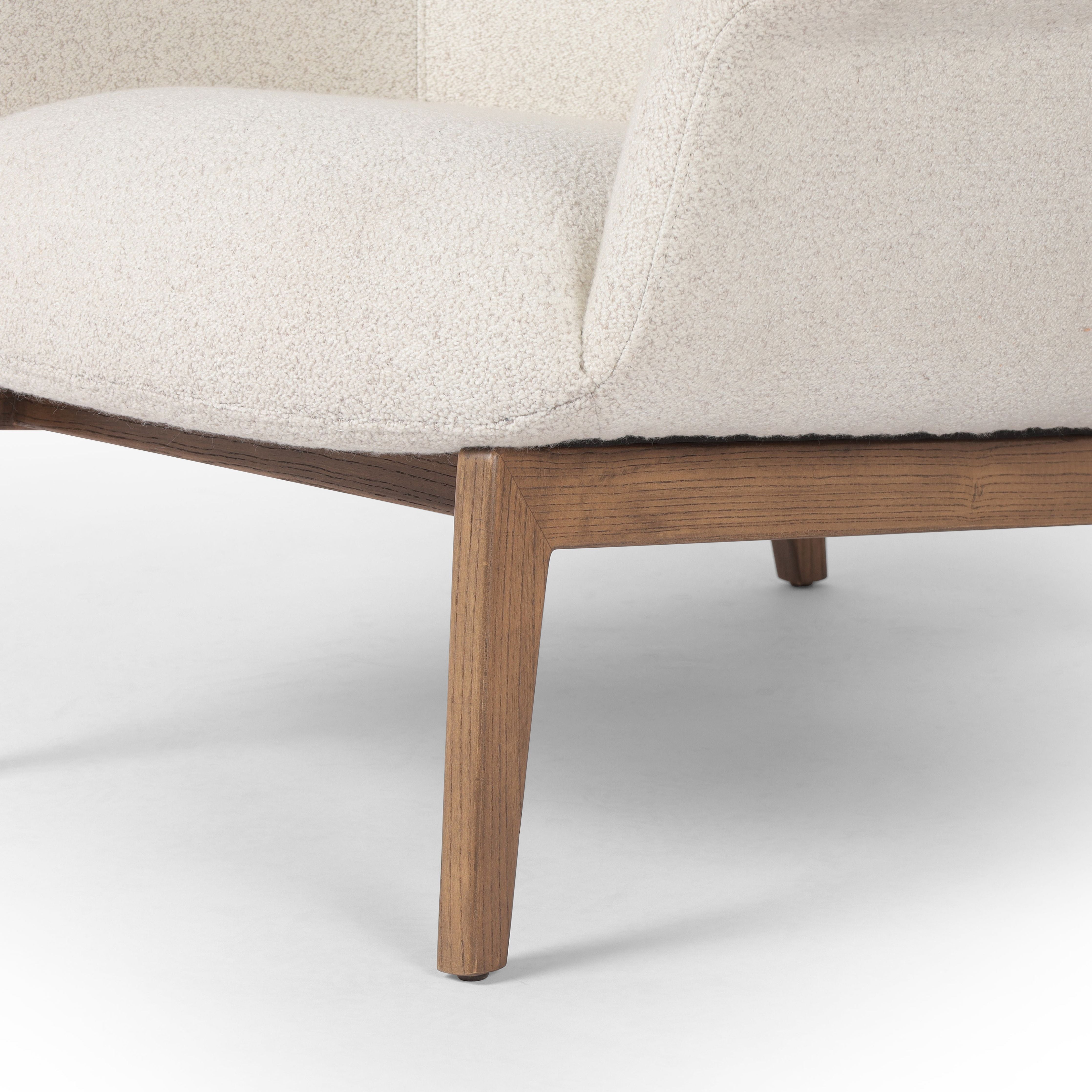 The classic wingback chair is updated with a midcentury-style base. Flared arms and a high winged back with blind tufting offer all-around comfort. Upholstered in a heavily textured boucle performance fabric bringing movement and everyday function to the piece. Amethyst Home provides interior design, new construction, custom furniture, and area rugs in the Nashville metro area.