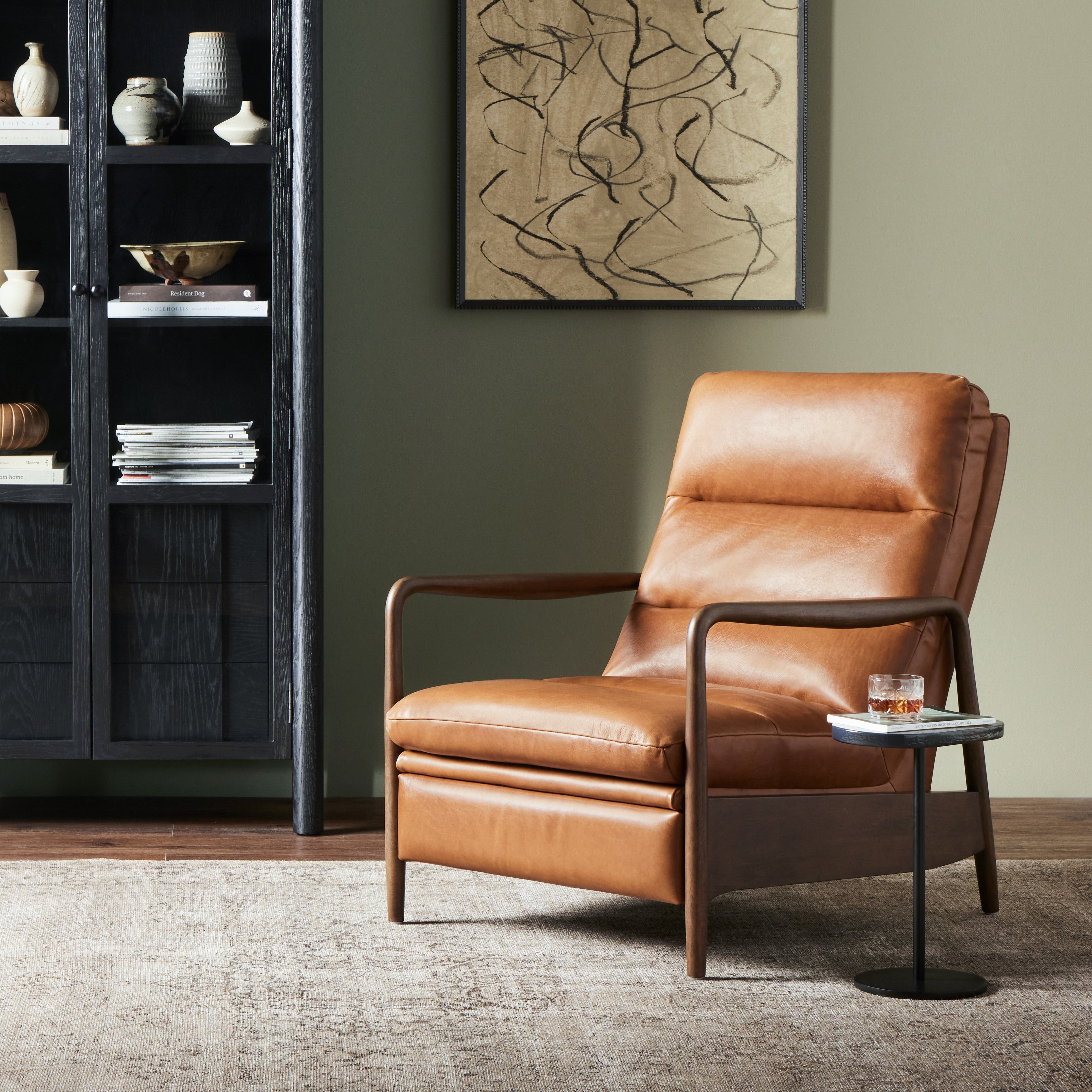 A sleek seat with hidden push-back reclining functionality. This midcentury-inspired recliner features wide chunky channeling paired with slim paddle arms and a tapered wood frame. Designed with a high seat and high back for extra comfy support. Upholstered in a timeless tobacco-hued leather made in a family-owned tannery in Thailand. Amethyst Home provides interior design, new construction, custom furniture, and area rugs in the Miami metro area.