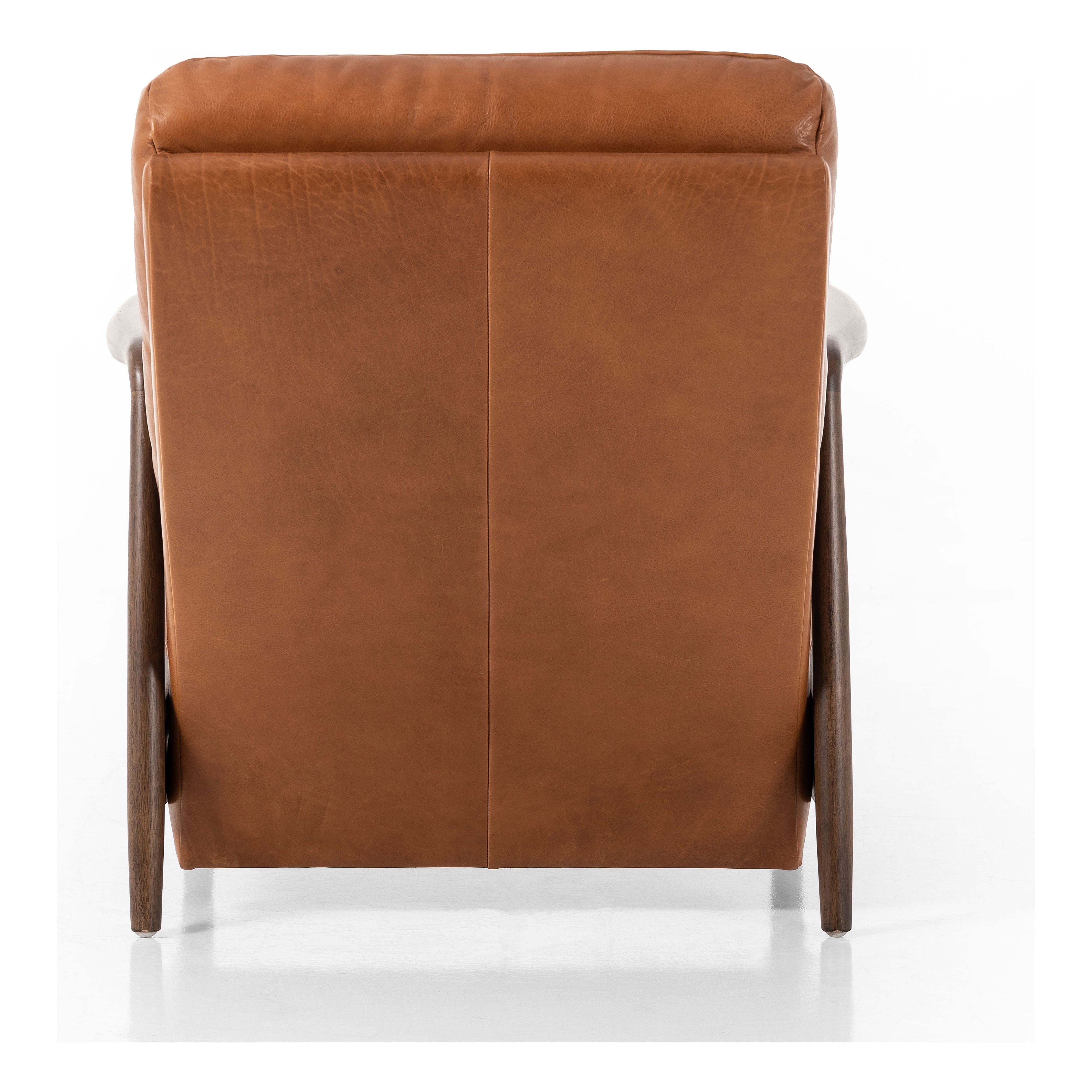 A sleek seat with hidden push-back reclining functionality. This midcentury-inspired recliner features wide chunky channeling paired with slim paddle arms and a tapered wood frame. Designed with a high seat and high back for extra comfy support. Upholstered in a timeless tobacco-hued leather made in a family-owned tannery in Thailand. Amethyst Home provides interior design, new construction, custom furniture, and area rugs in the Tampa metro area.
